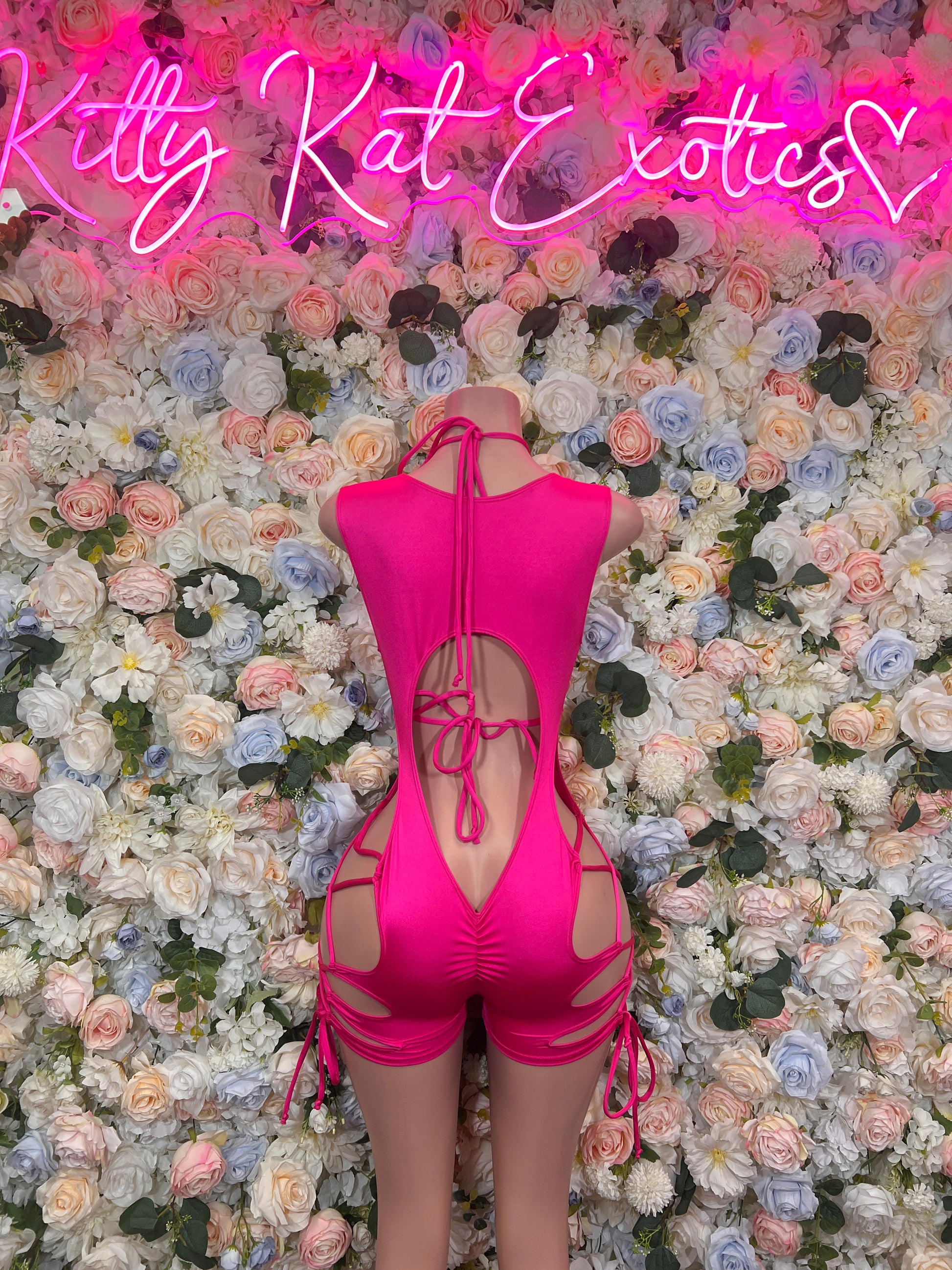 Pink Bottlegirl Bodysuit shown on mannequin against floral backdrop, ideal for exotic dancewear and club wear.