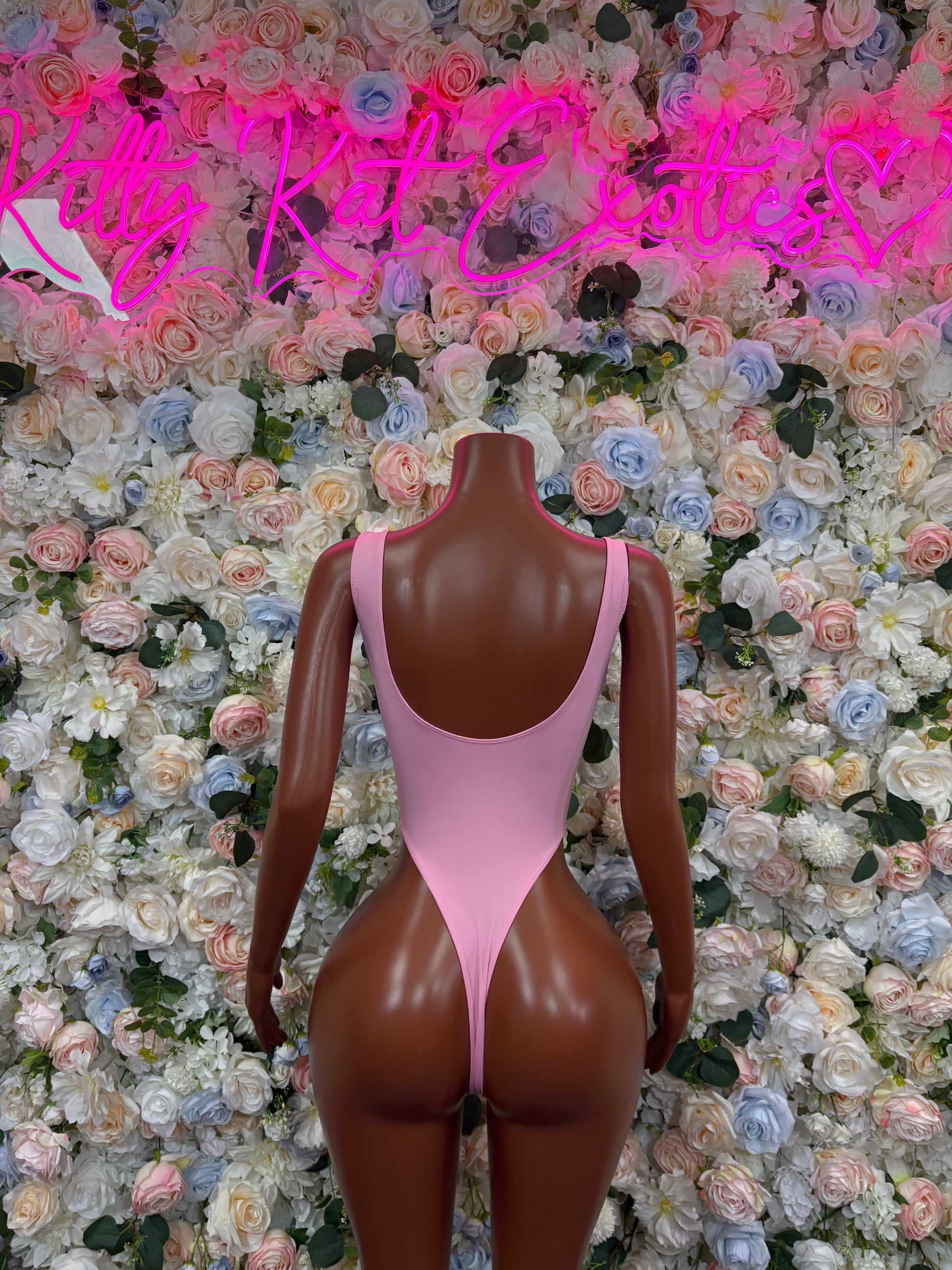 Pink one-piece bodysuit with deep V neckline and thin straps