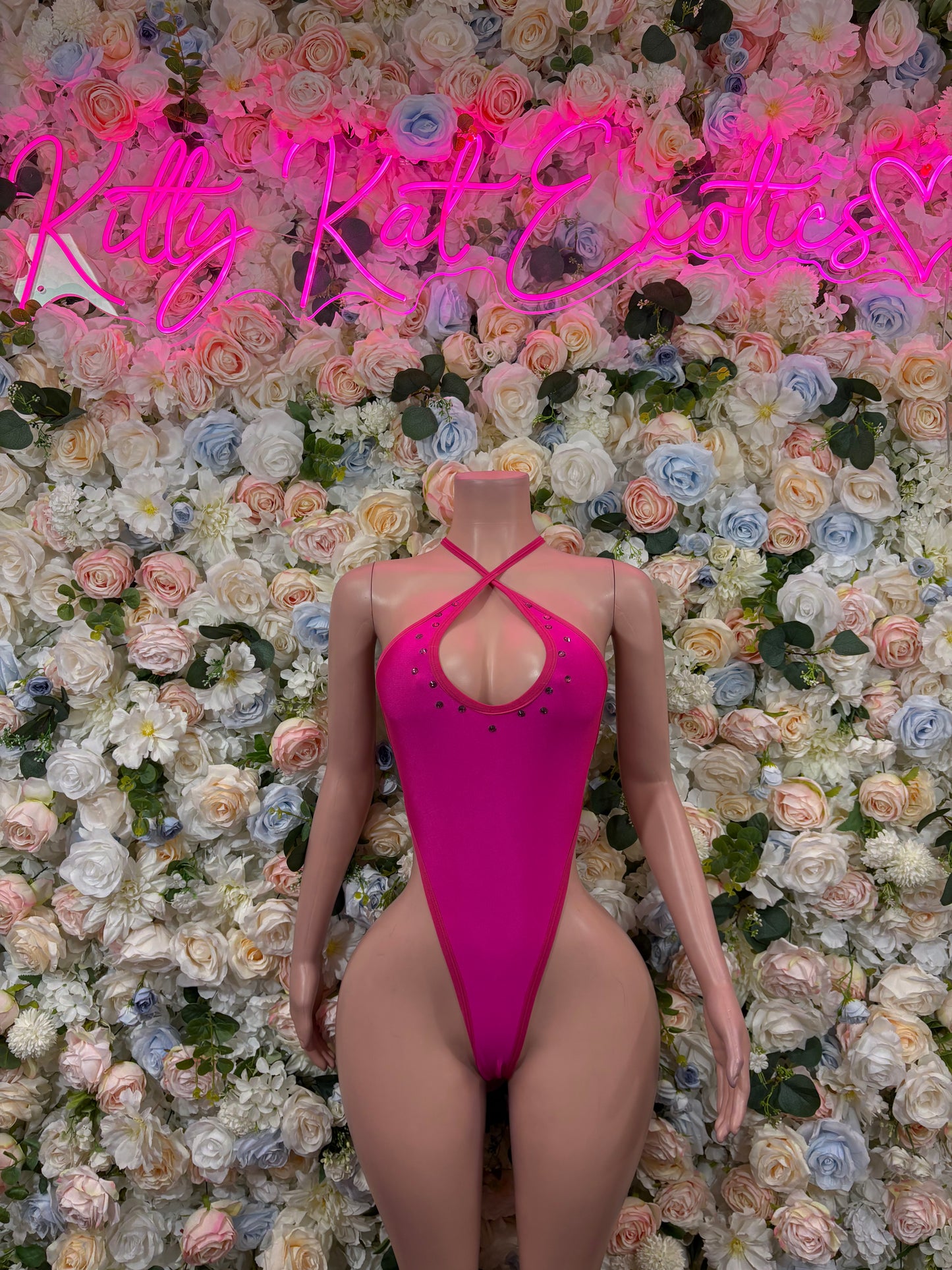 Pink high-cut backless bodysuit with crisscross straps and small back studs