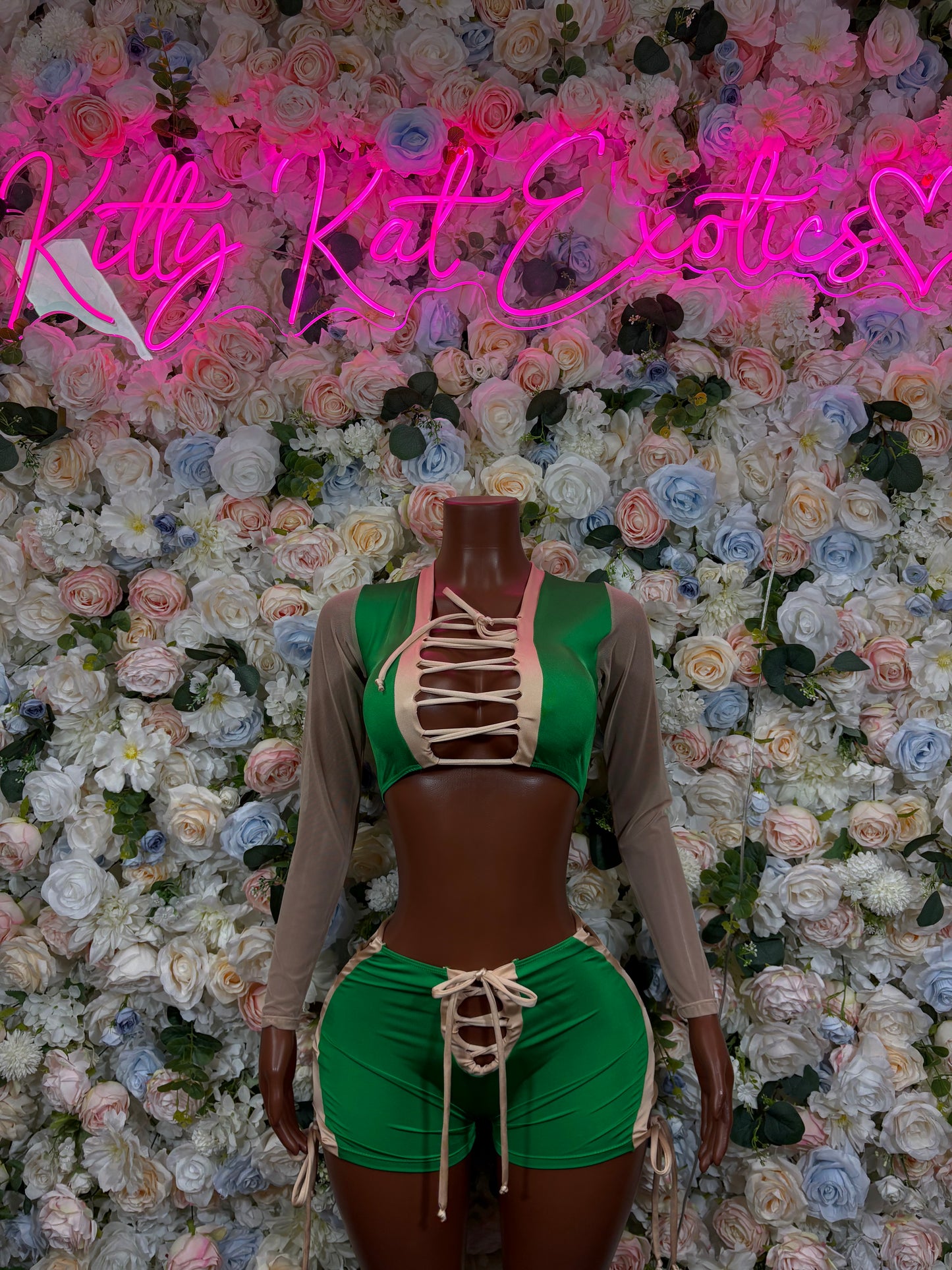 Green lace-up bodysuit with sheer long sleeves and corset-style front cutouts