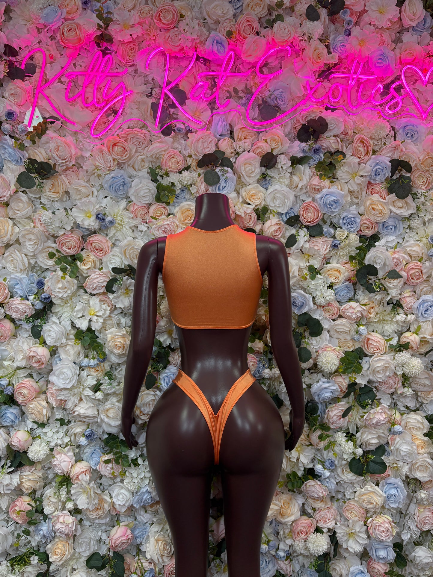 Two-piece orange cutout swimsuit with halter top and high-cut bottoms, back view