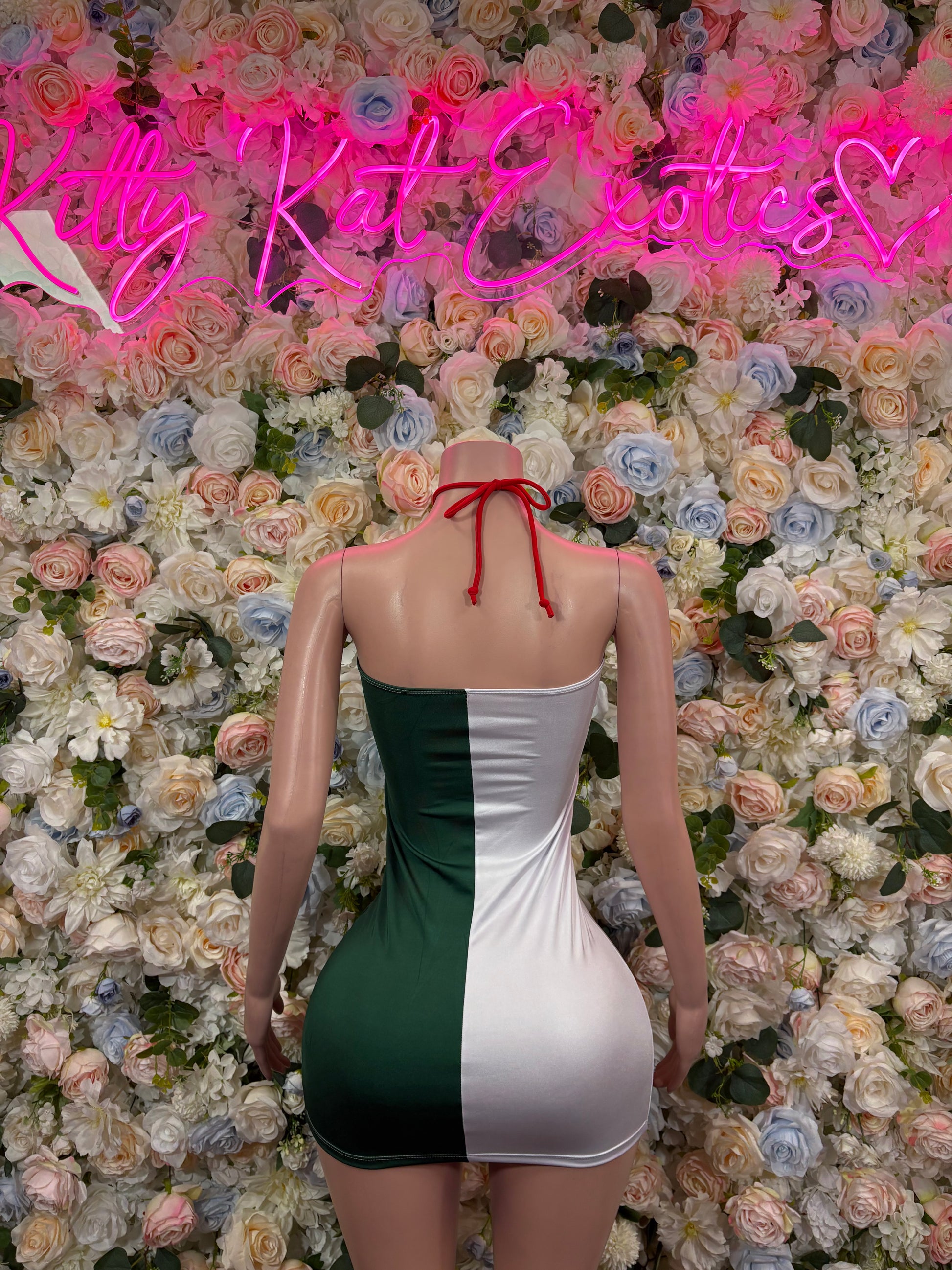 Backless mini dress in green, white, and red with halter neckline and tie straps.