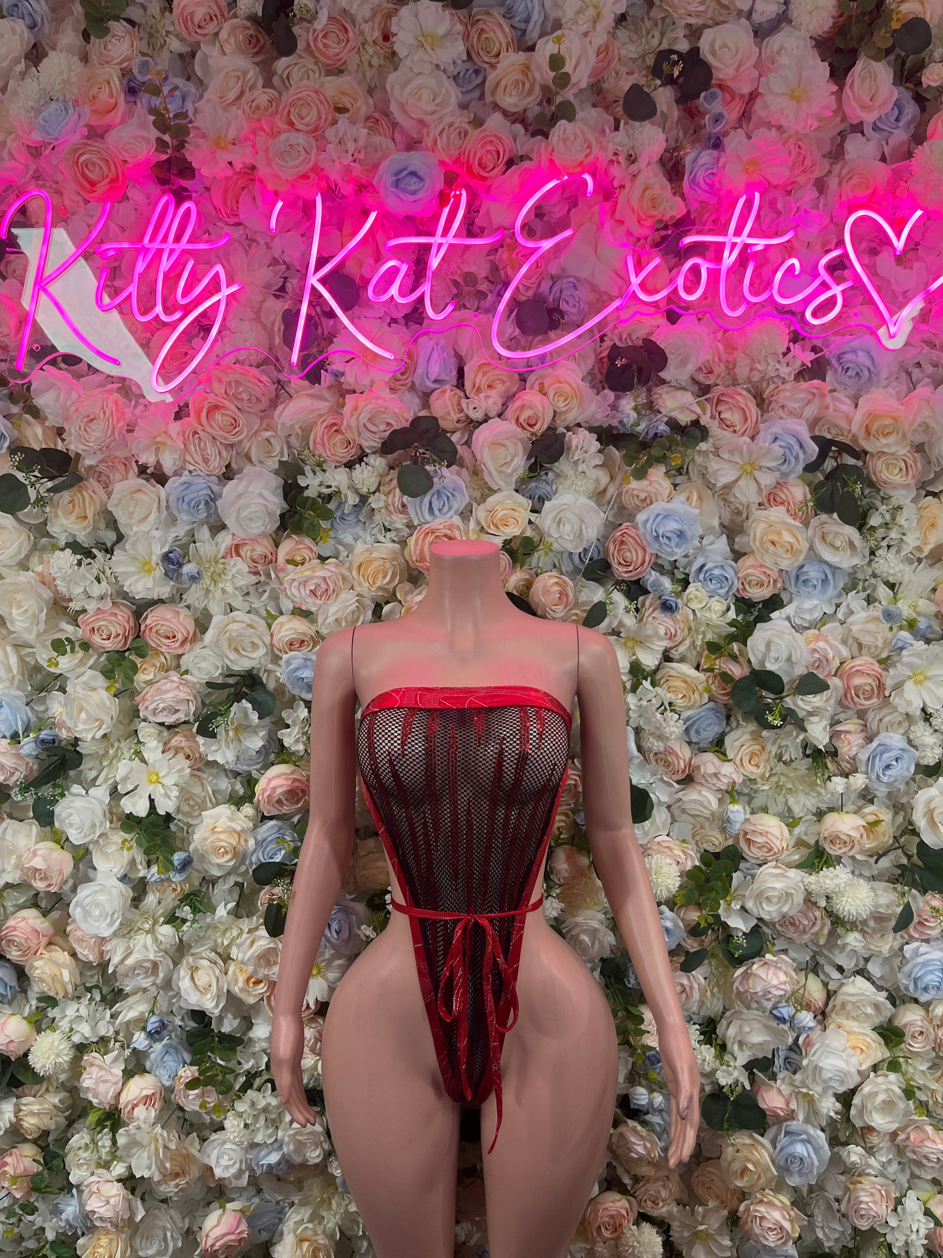 Red one-piece strappy bodysuit with mesh panels and crisscross back straps