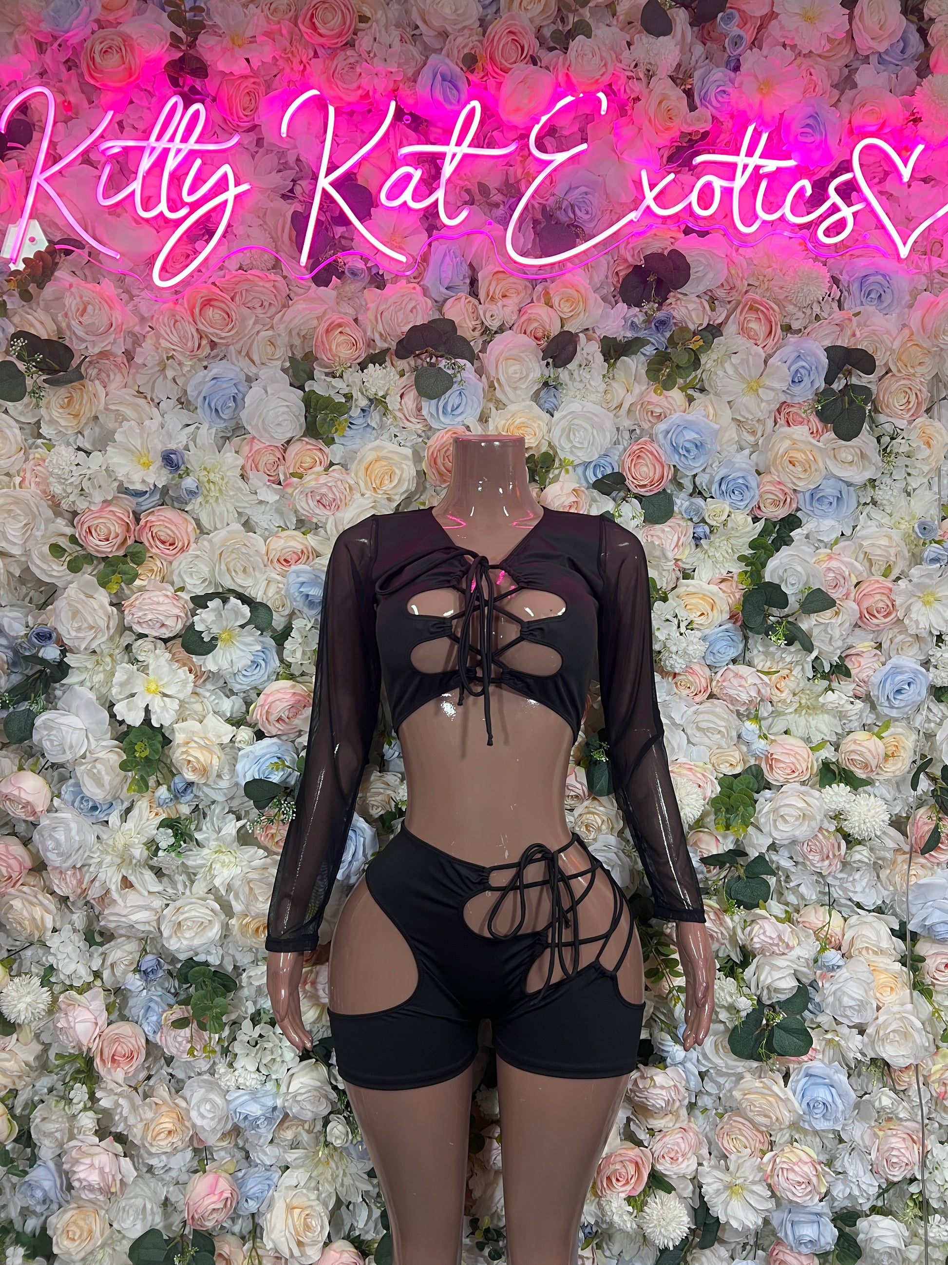 Black lace-up sheer long-sleeve bodysuit with chest cutouts and tie front; shorts