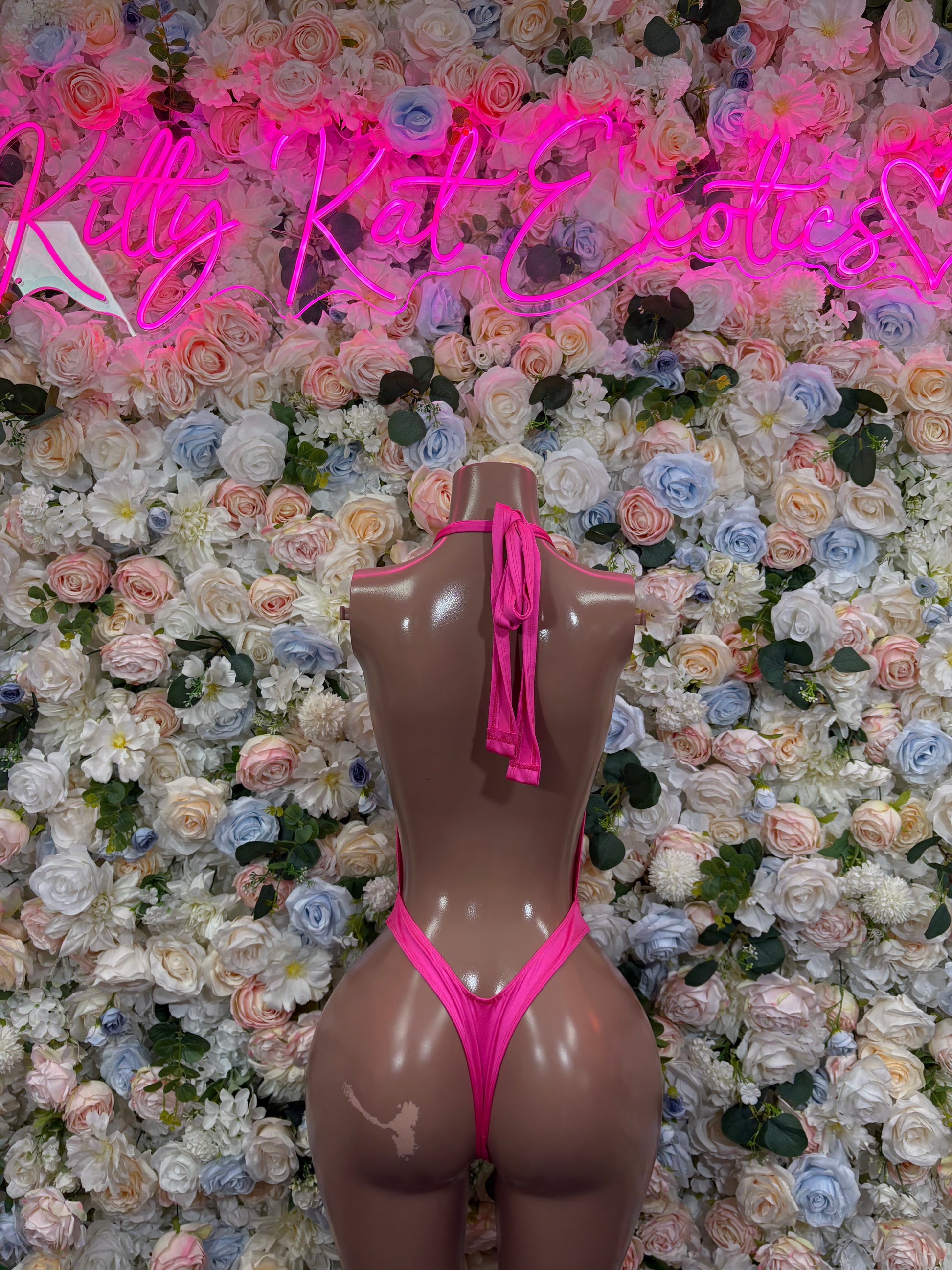 Pink one-piece bodysuit with halter tie, deep V front, and chain fringe detail