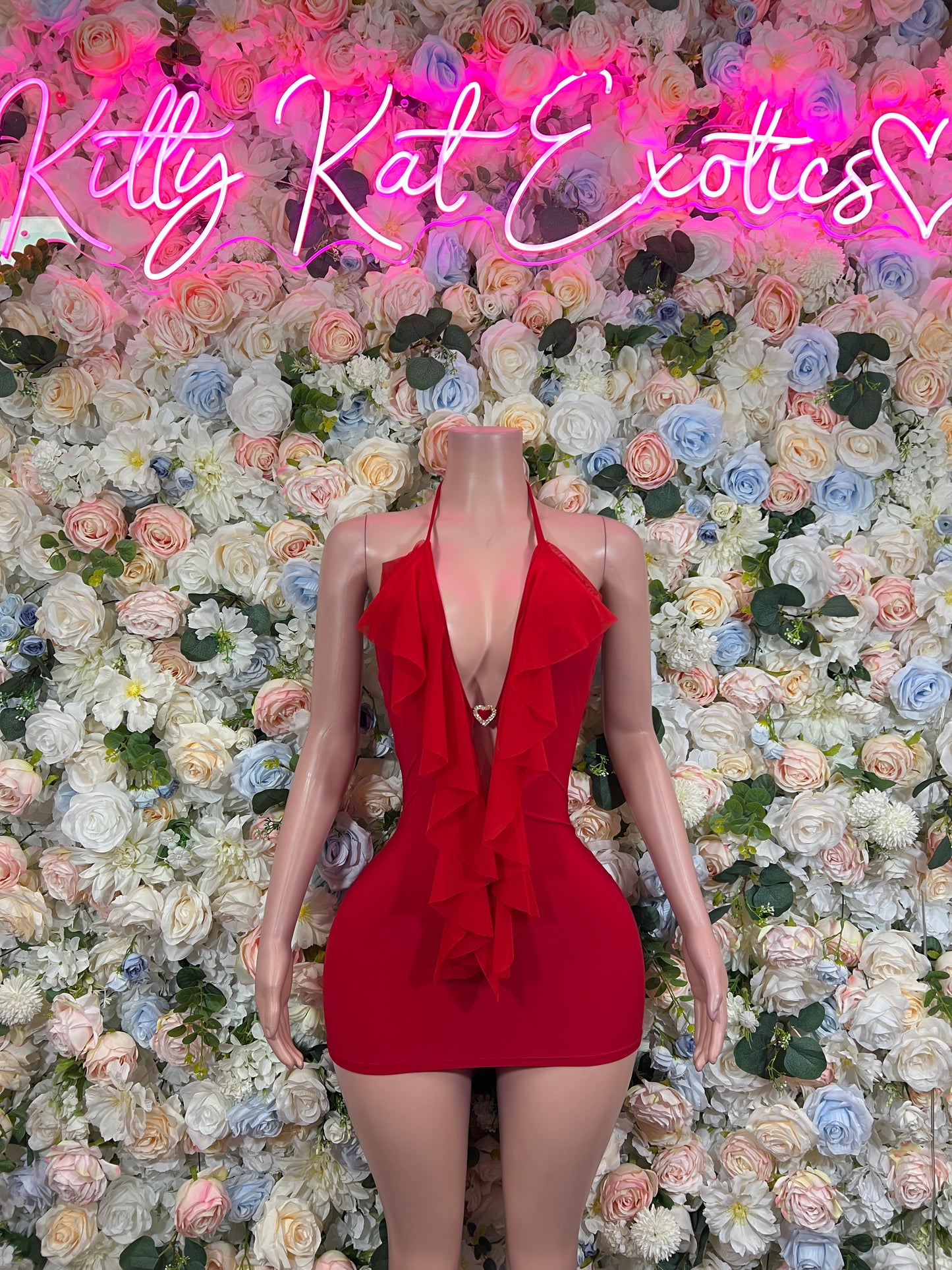 Red plunge halter bodycon mini dress on mannequin, layered ruffle chest detail