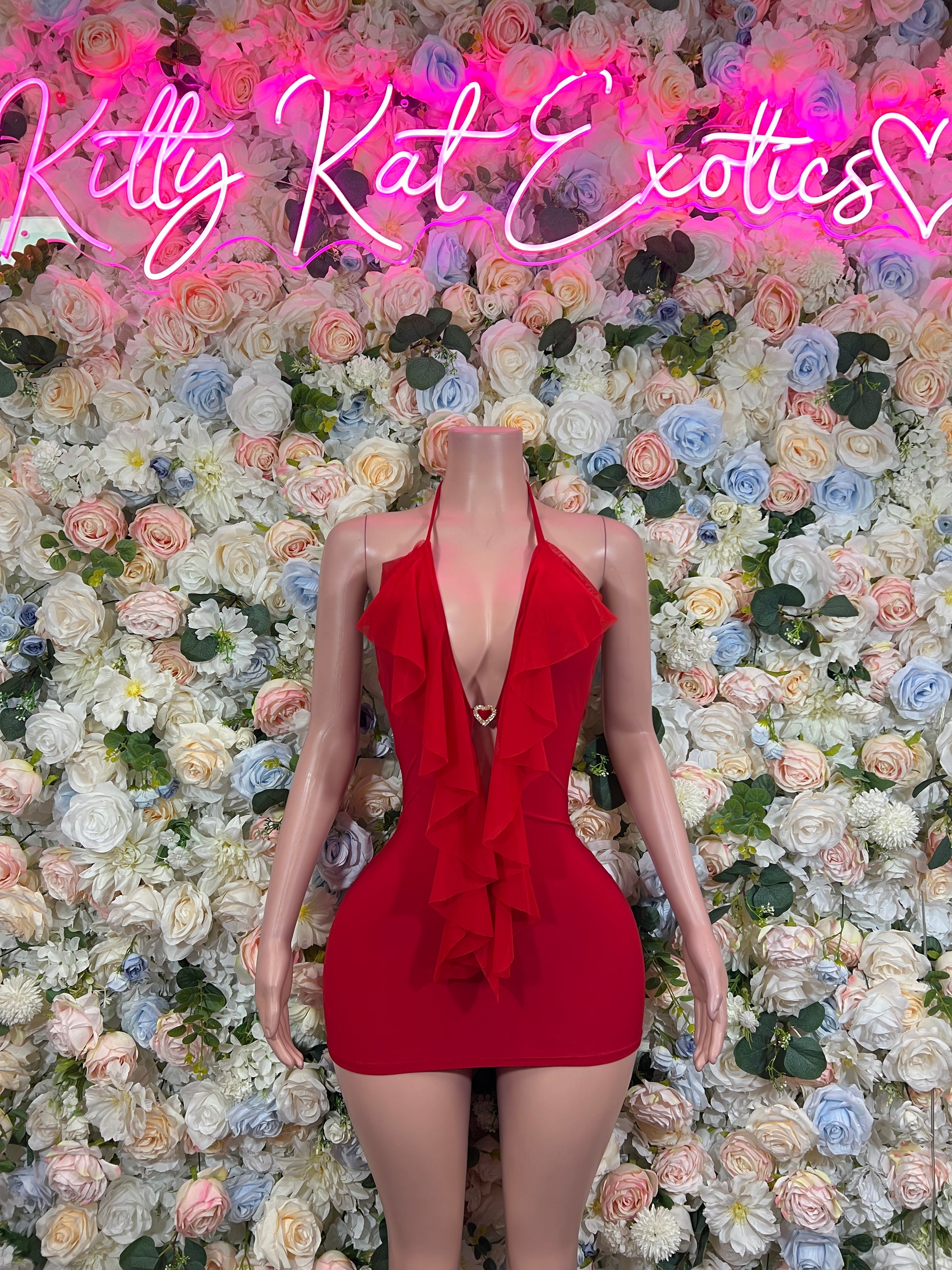 Red plunge halter bodycon mini dress on mannequin, layered ruffle chest detail