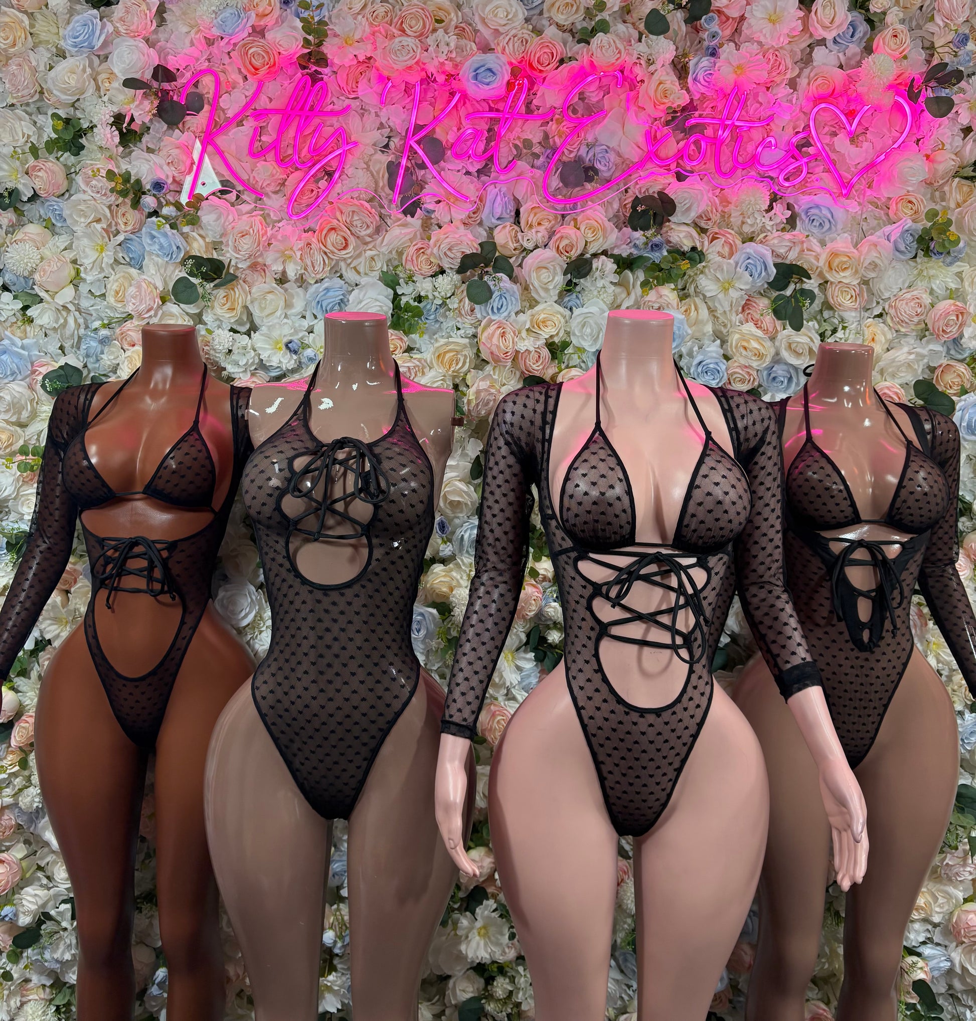 Black sheer mesh bodysuit, long sleeves, heart pattern, lace-up front; four mannequins