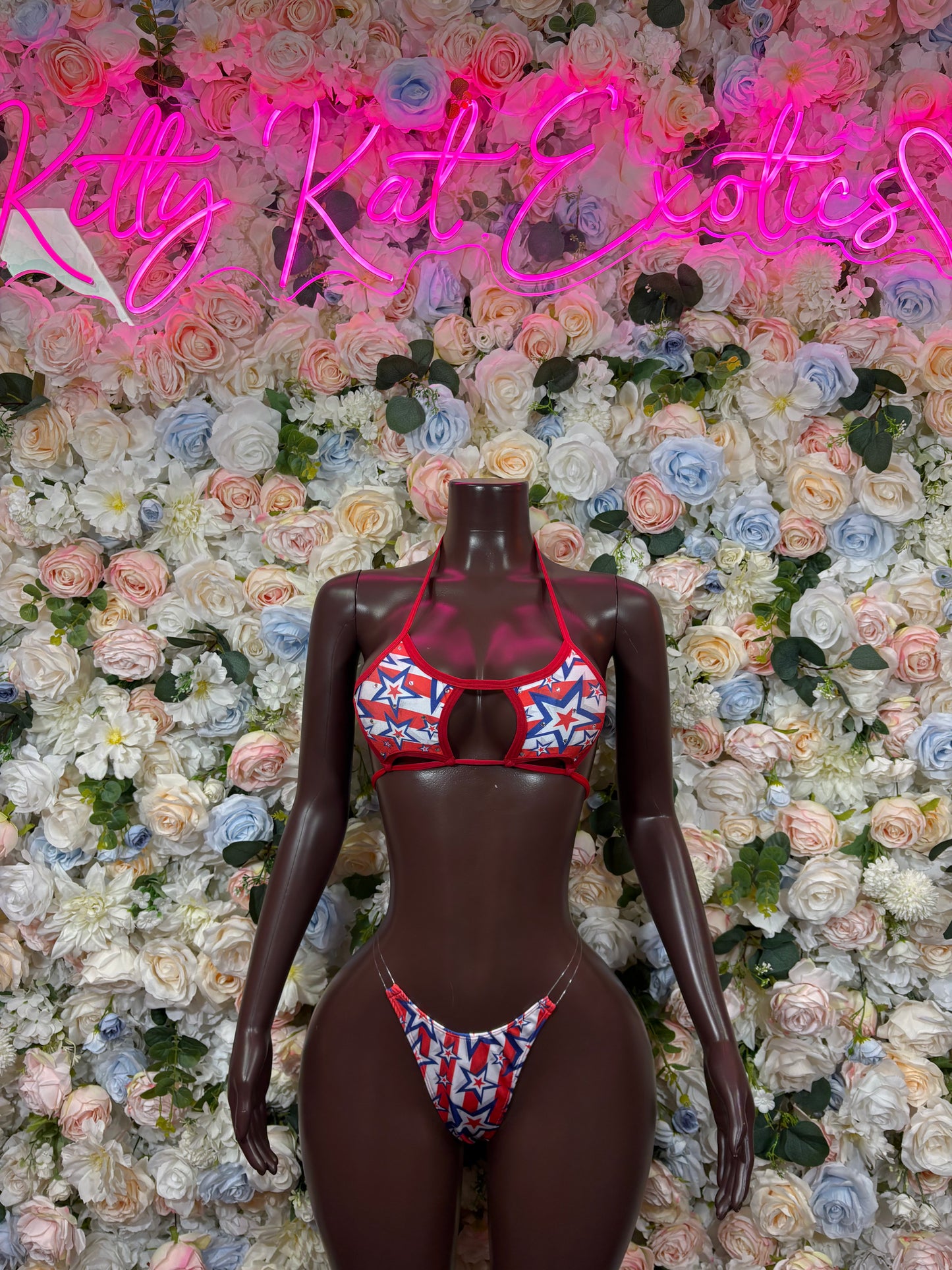 USA flag bikini set on dark mannequin, red triangle top with blue star panel, matching bottoms