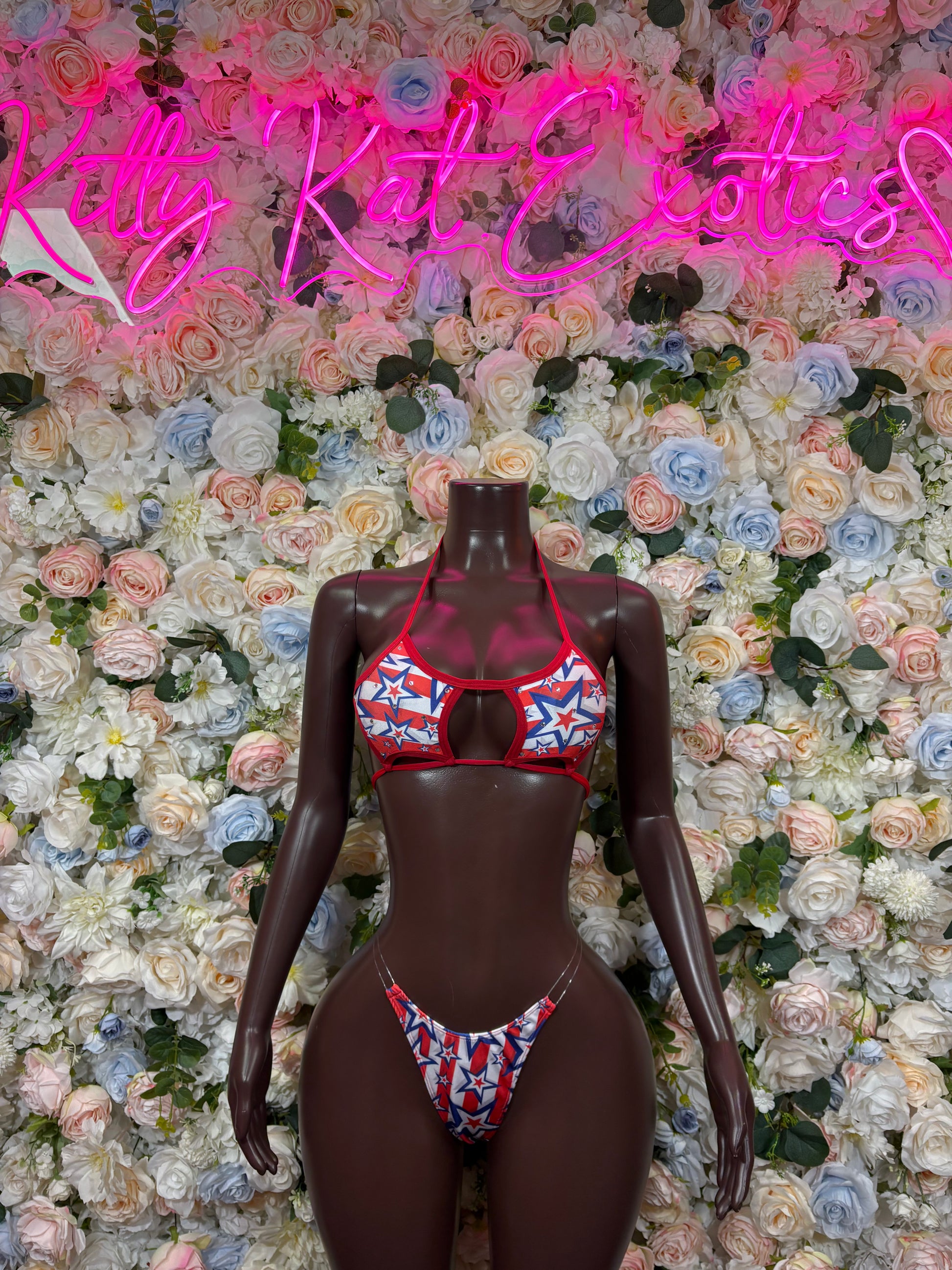 USA flag bikini set on dark mannequin, red triangle top with blue star panel, matching bottoms