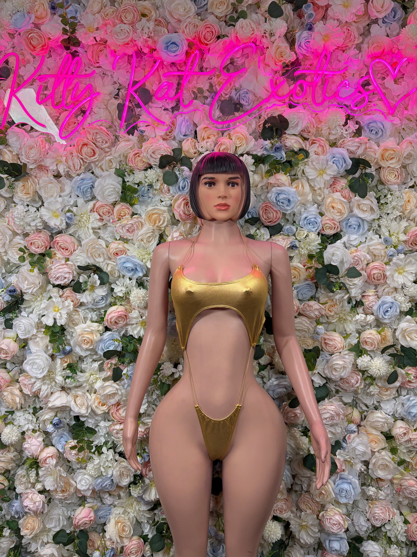 Gold metallic slingshot-style bodysuit with front cutout and high-leg bottoms