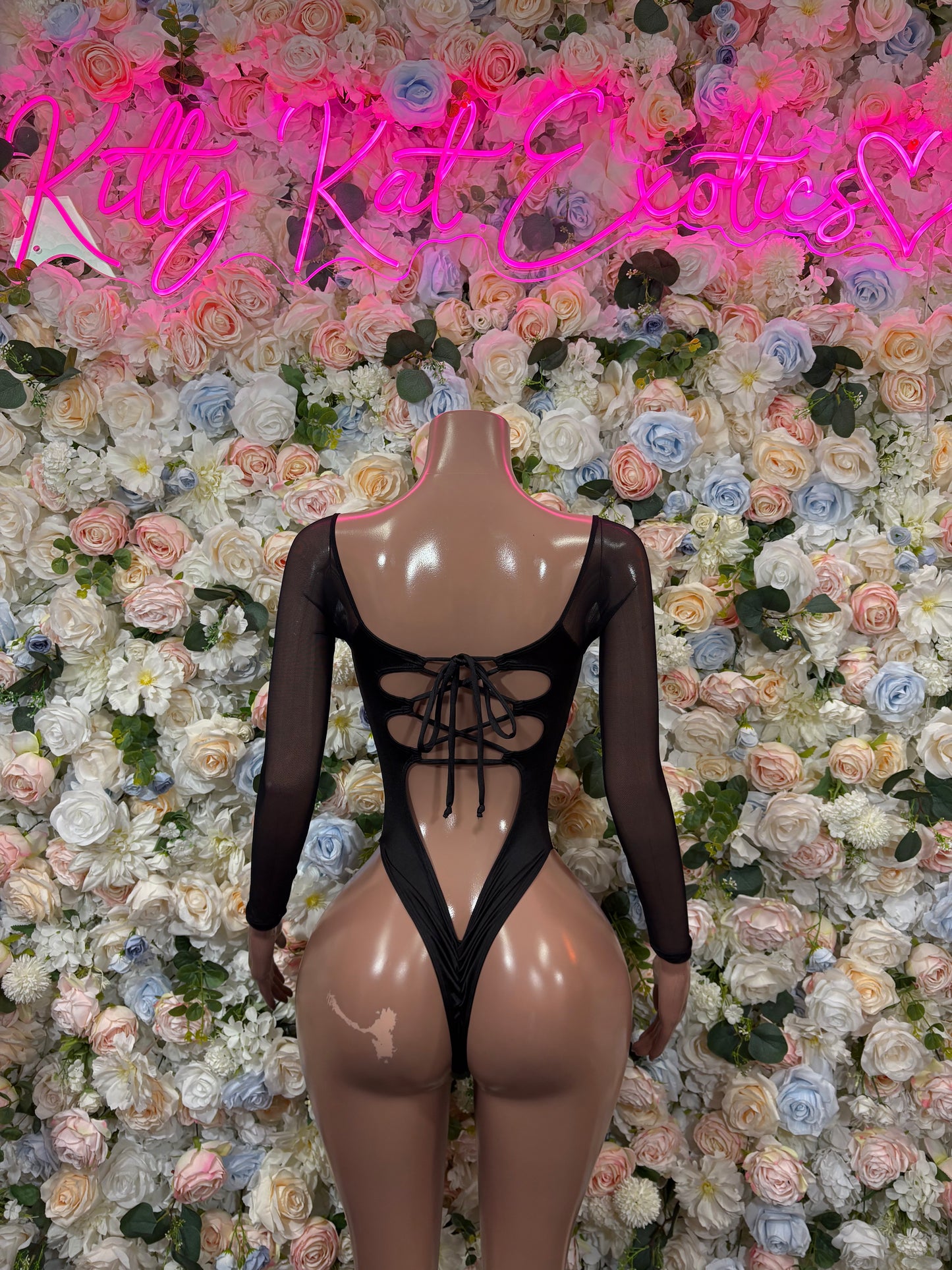 Camo print bodysuit with black long sleeves and center lace-up cutouts