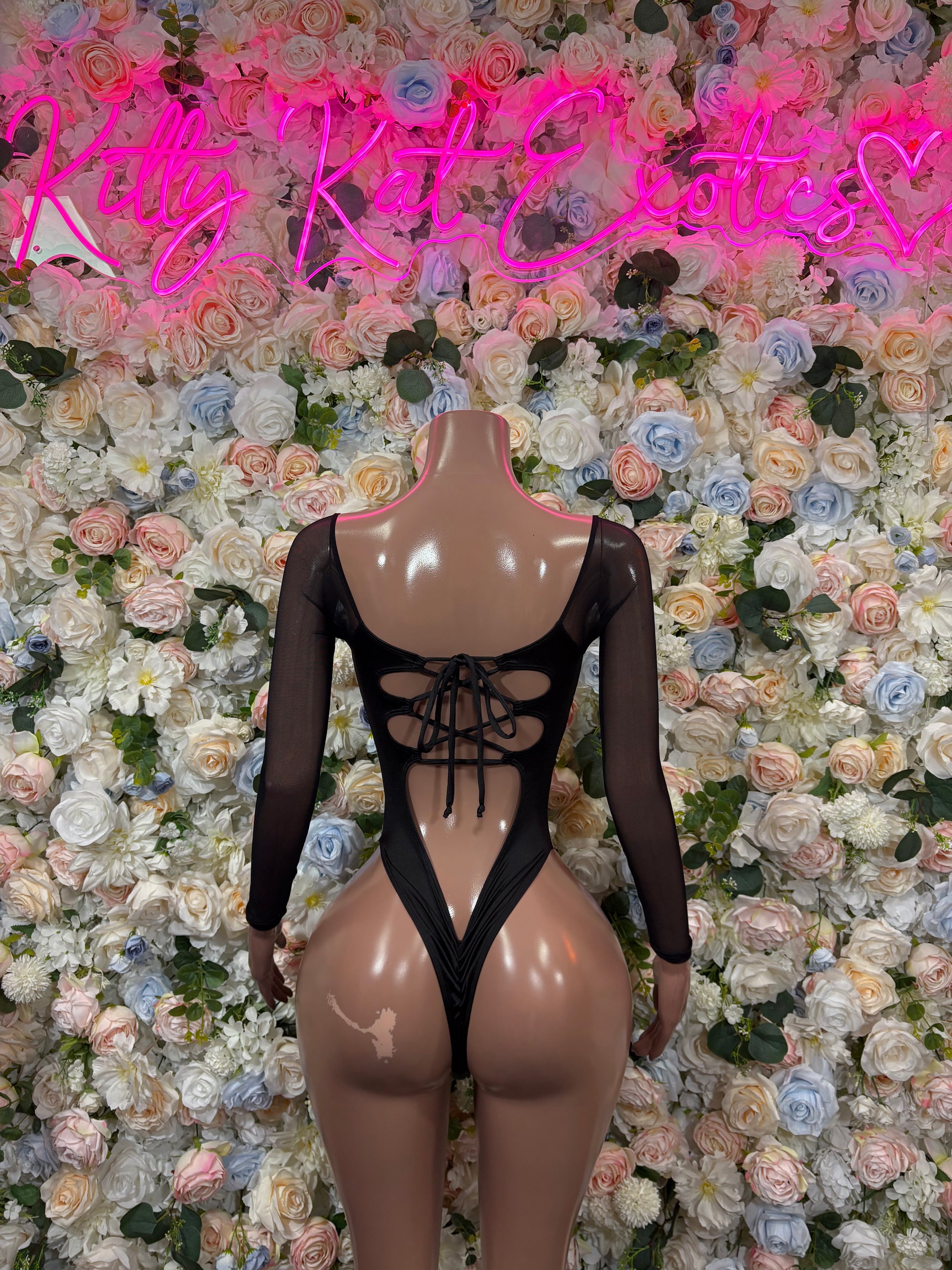 Camo print bodysuit with black long sleeves and center lace-up cutouts