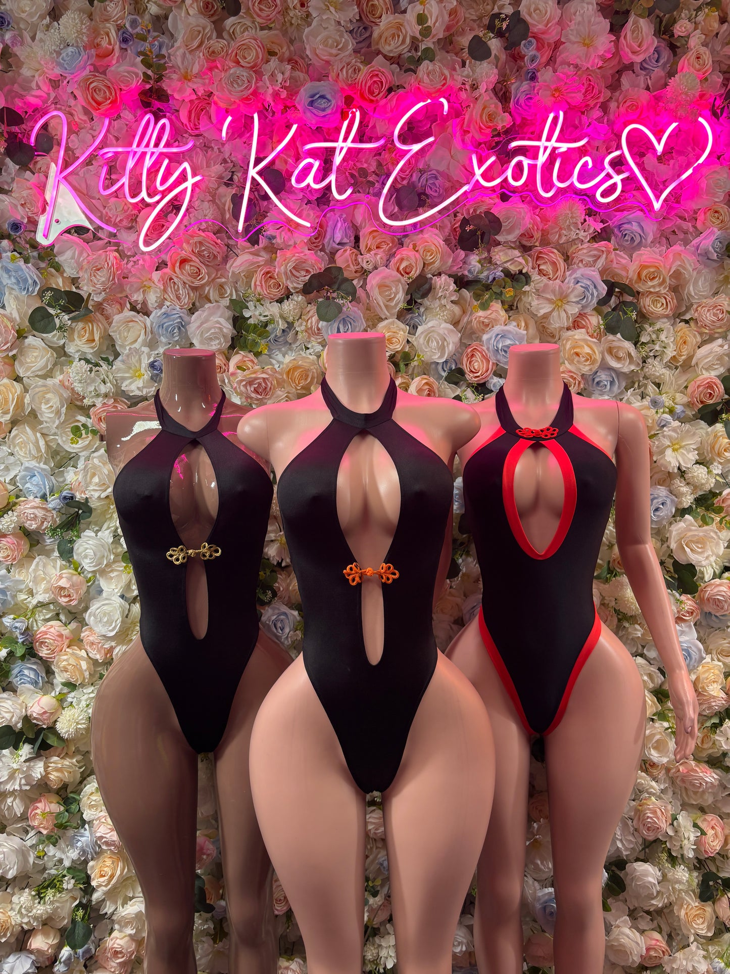Cutout one-piece bodysuits on models: black halter fronts and a red halter suit