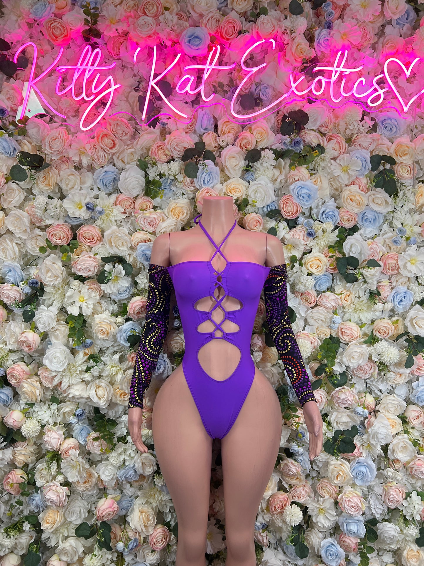 Purple bodysuit with crisscross cutout straps and long black sequin sleeves