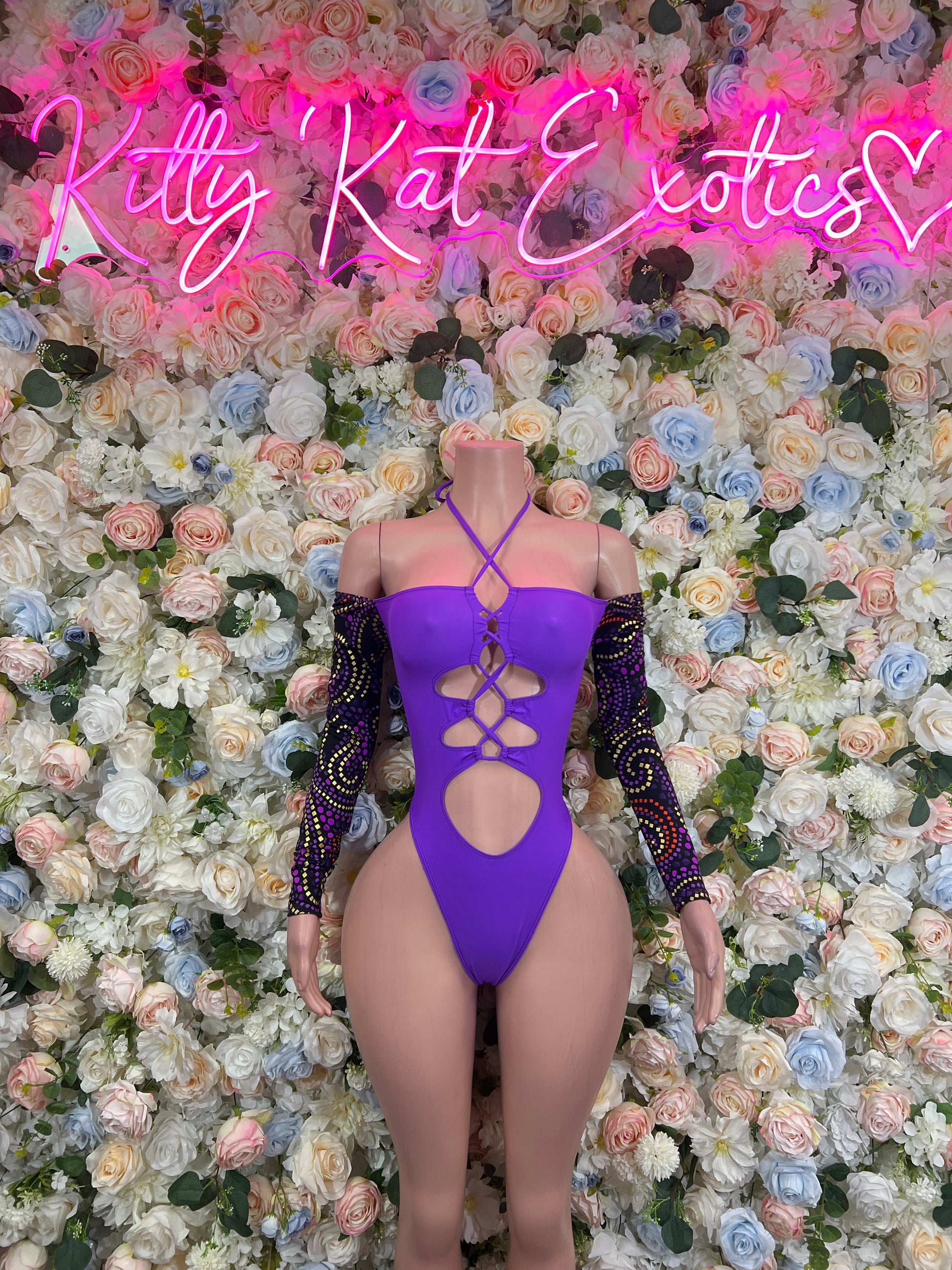 Purple bodysuit with crisscross cutout straps and long black sequin sleeves