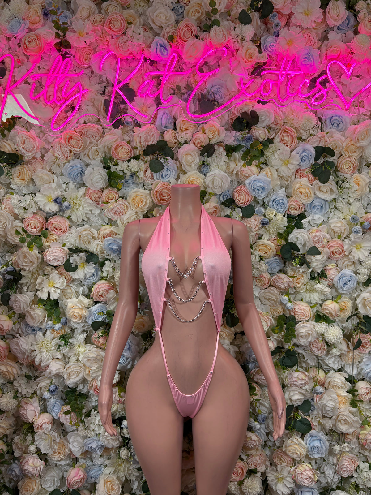 Pink slingshot lingerie set, front view, triangle top with chain detail and thong