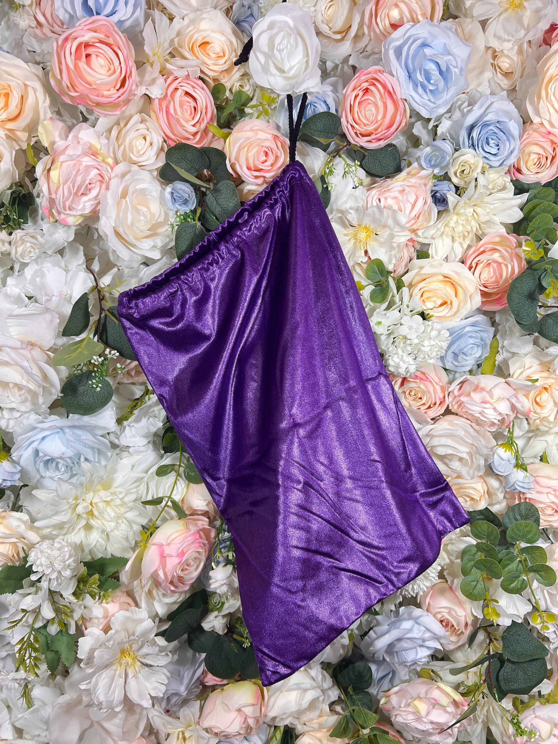 Purple velvet pouch bag with black handle loops and gathered top