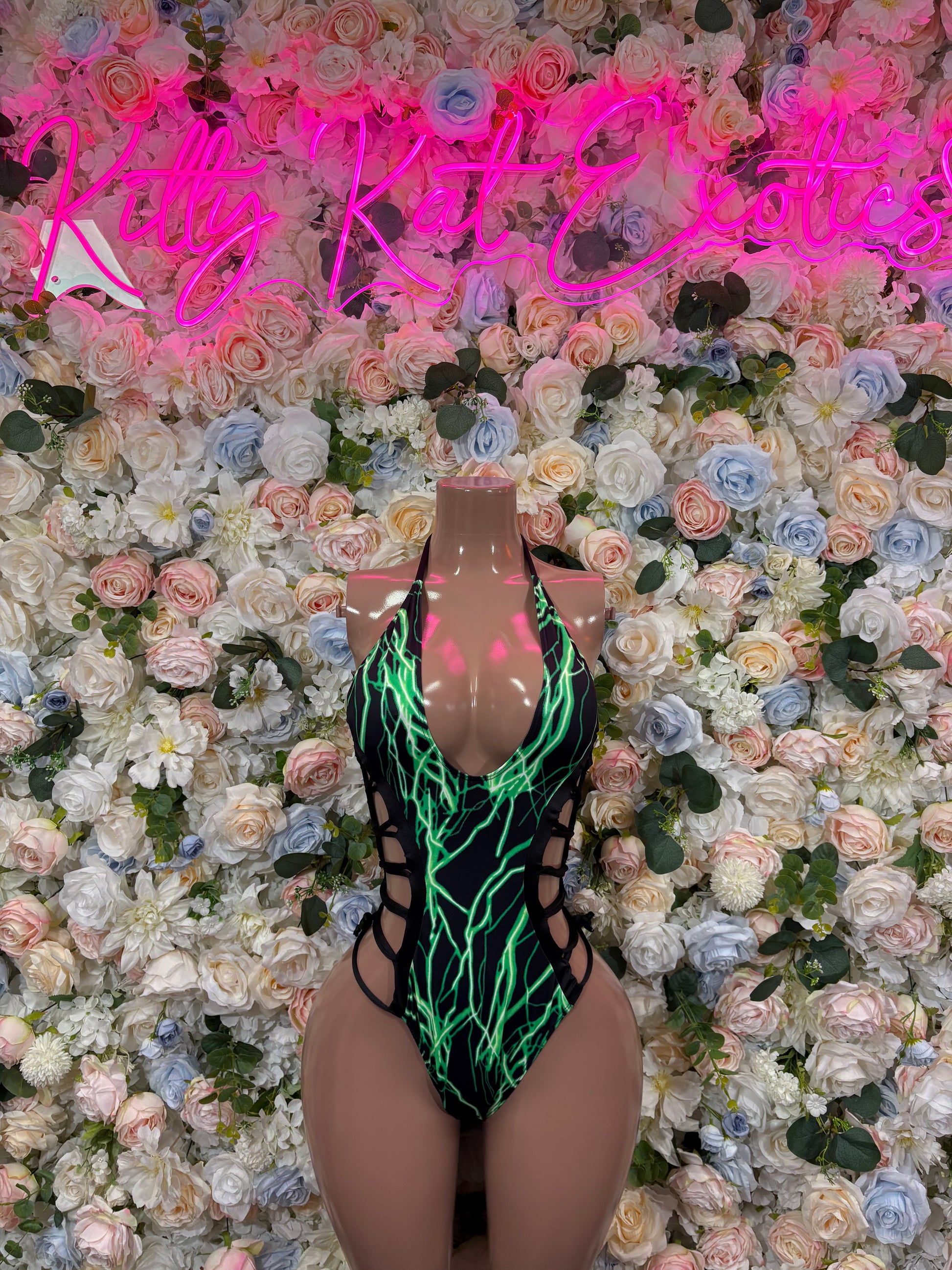 Green and black one-piece bodysuit with halter neck and crisscross trim