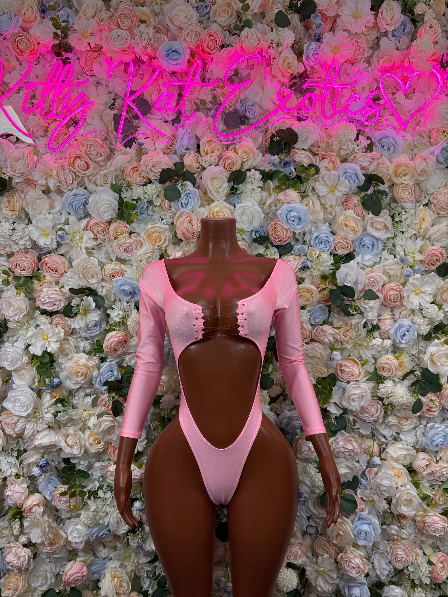 Pink long-sleeve bodysuit with scoop neckline and high-cut leg openings