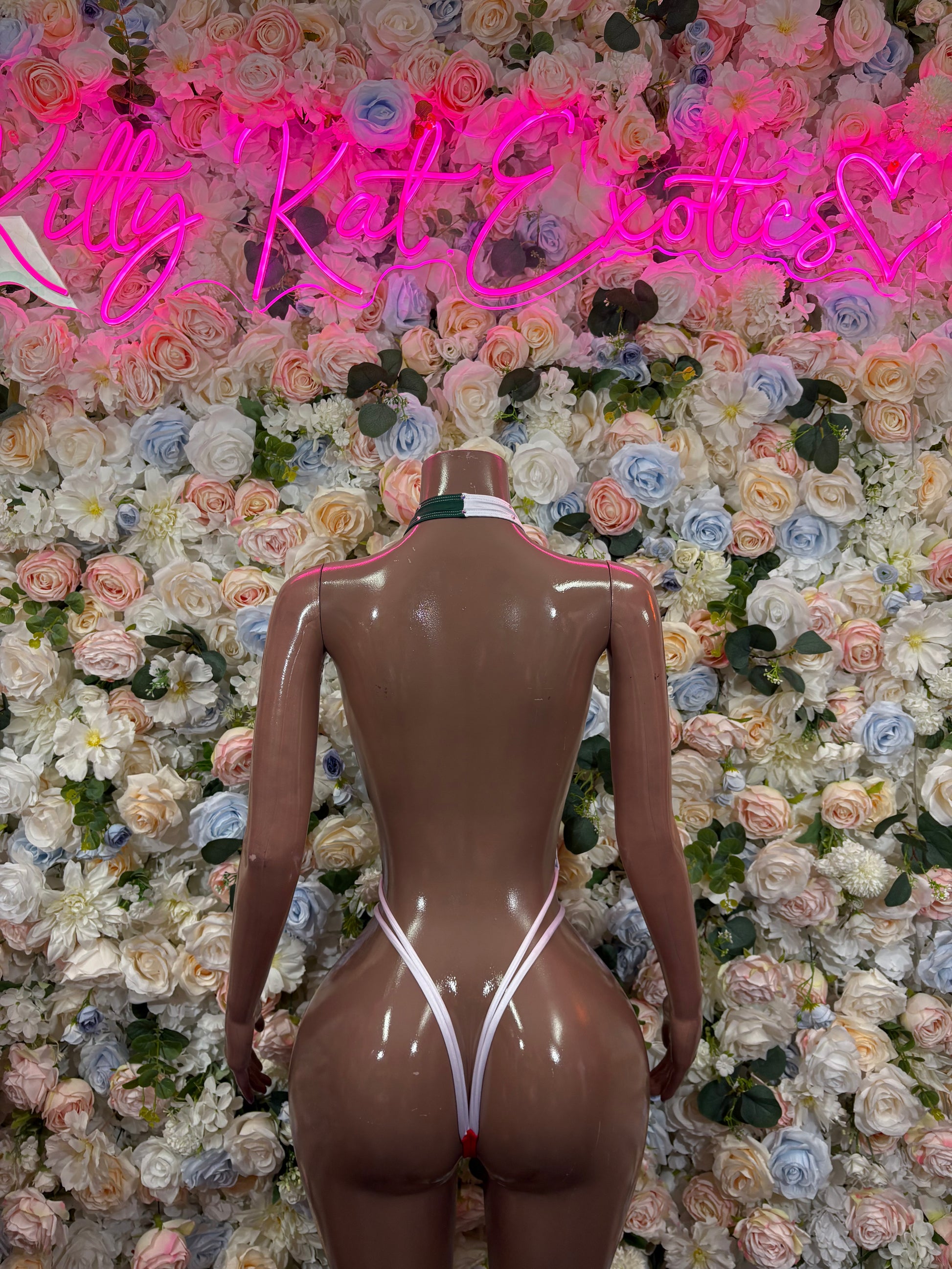 Back view one-piece swimsuit in green, red, and white with strappy back