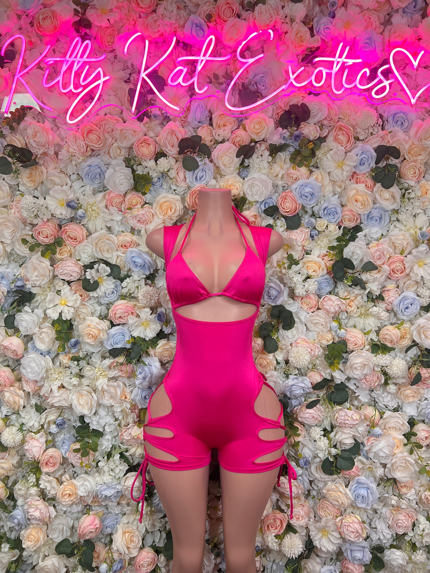 Pink Bottlegirl Bodysuit displayed on a mannequin against a floral background, perfect for exotic dancewear.