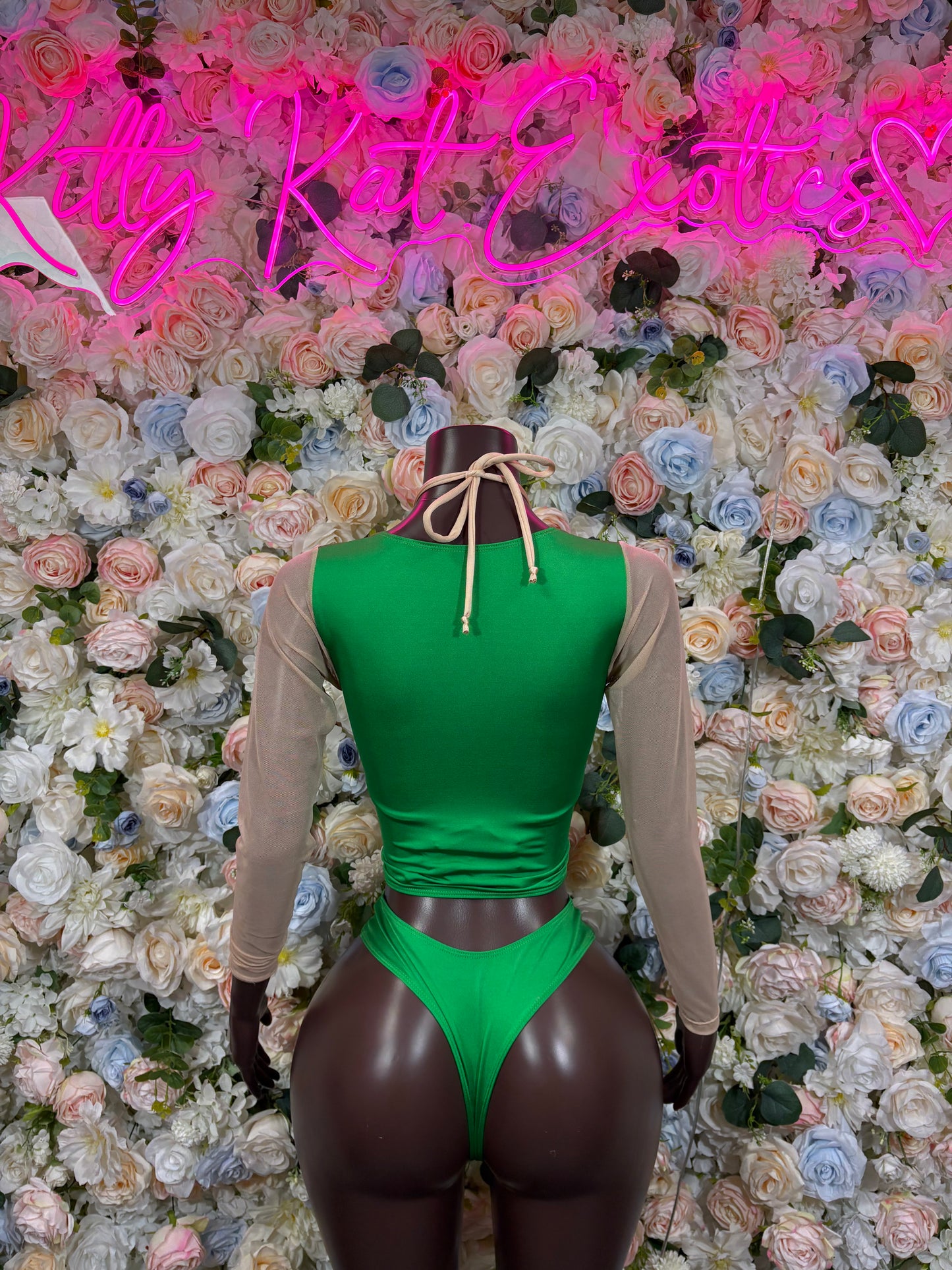 Green halter bodysuit with front lace-up detail and tie straps, long sleeves