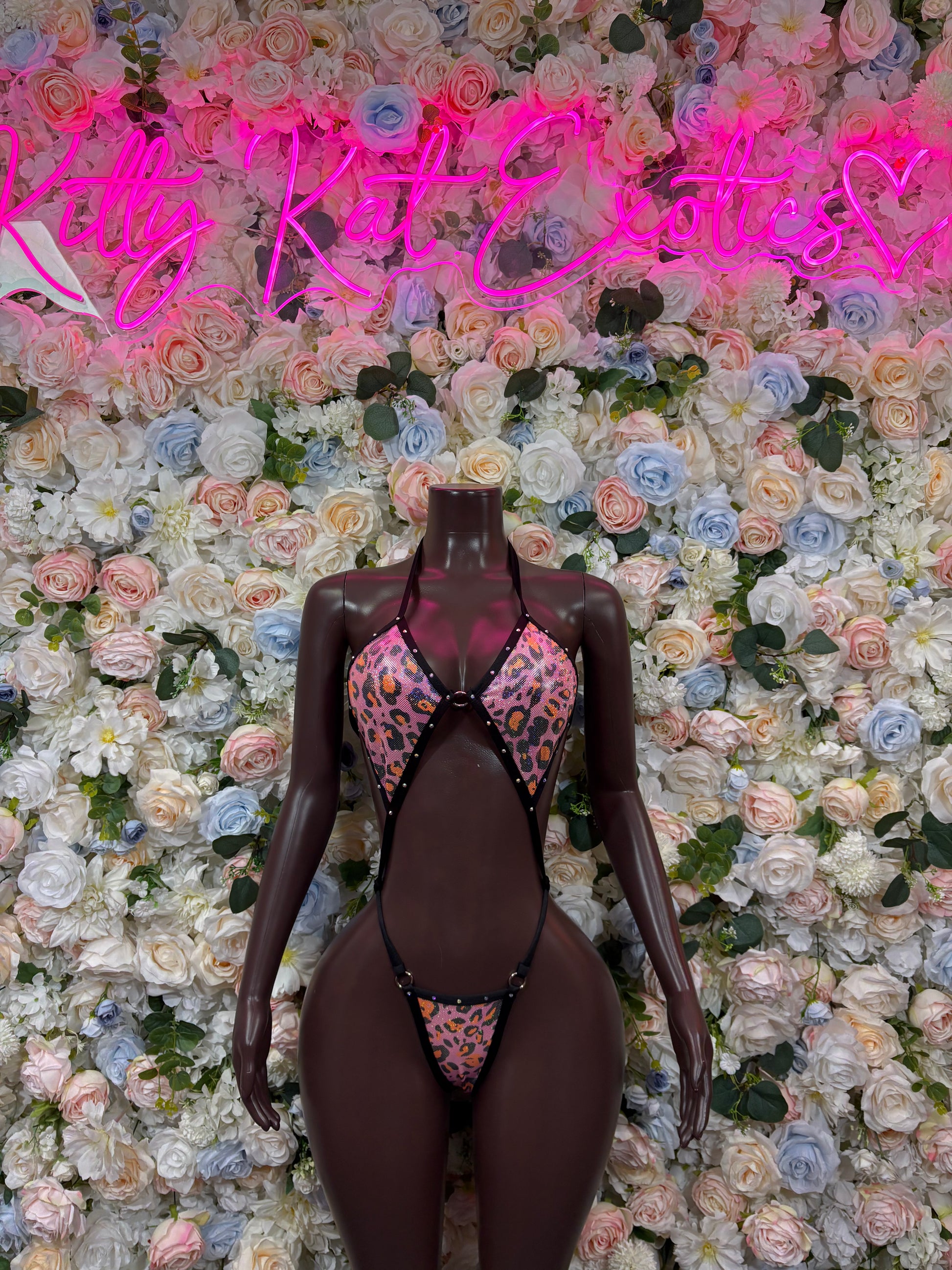 Cheetah print one-piece dancewear bodysuit in dark fabric with pink/orange accents, front V-neck
