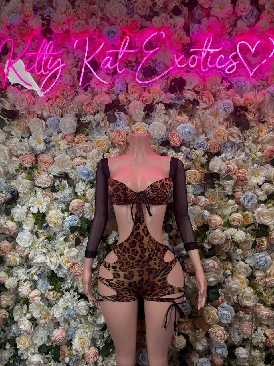 Leopard print bodysuit with long sheer sleeves, bow ties, and hip cutouts