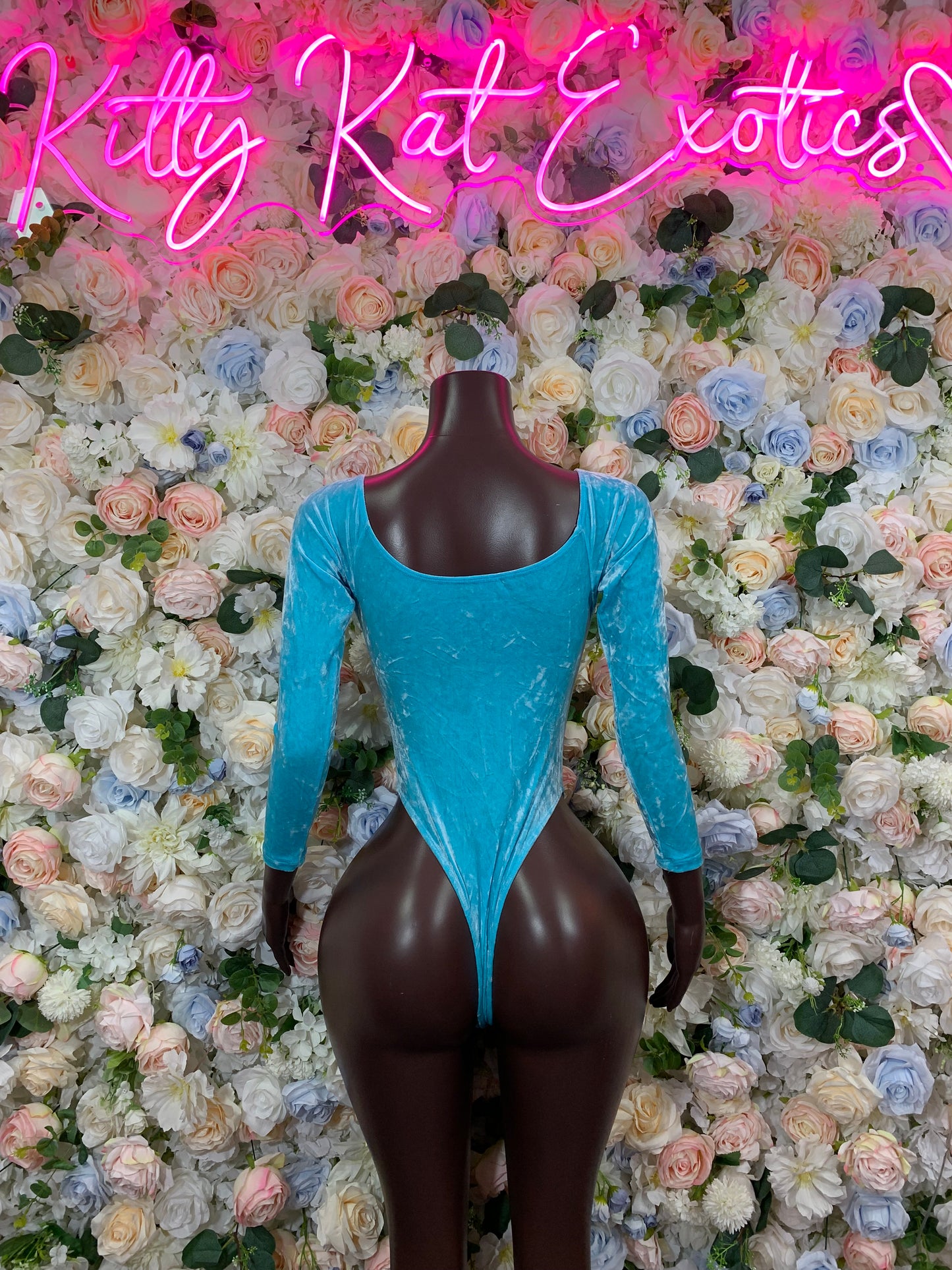 Turquoise long-sleeve one-piece rave bodysuit on mannequin, deep V plunge front