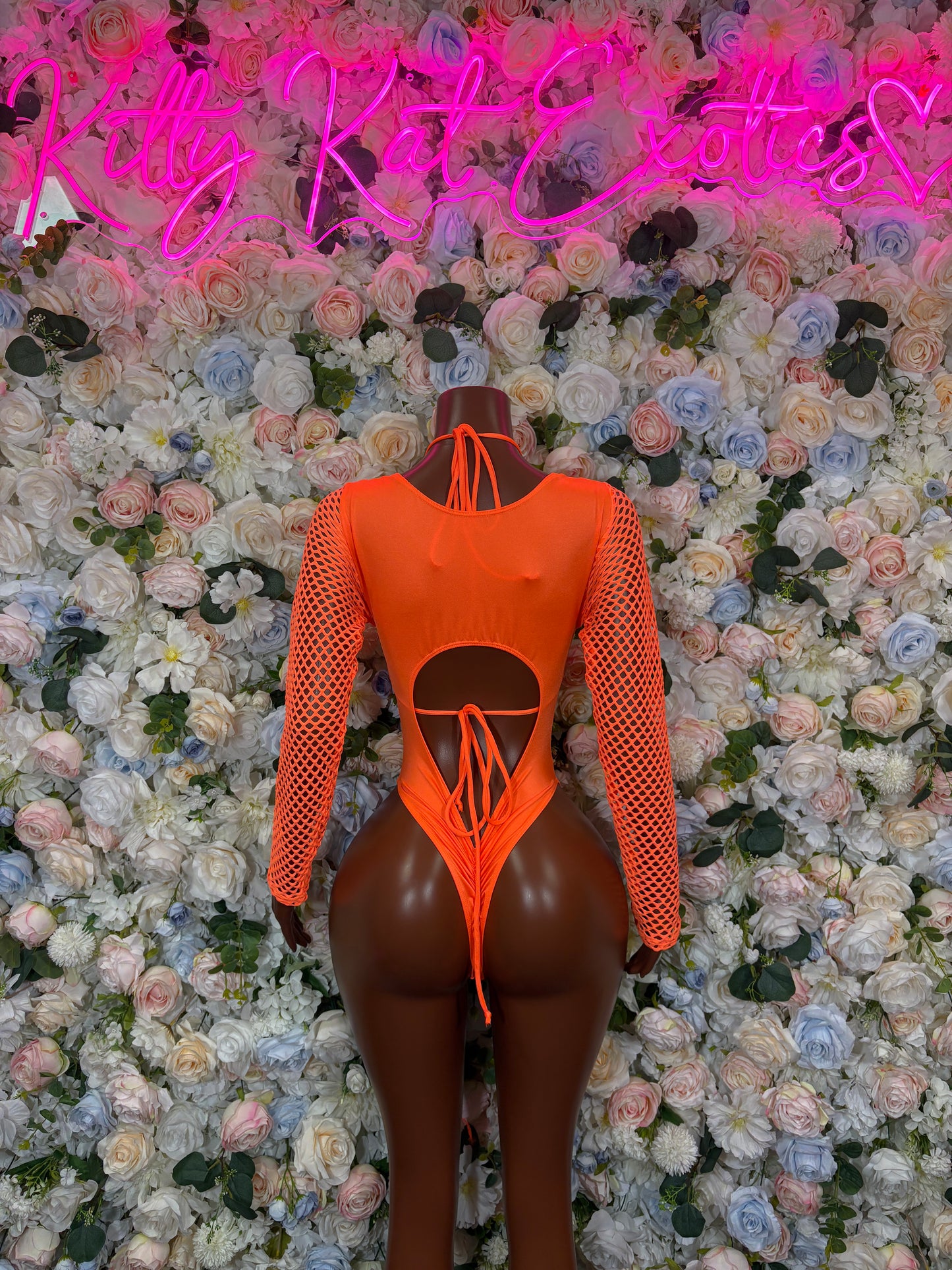 Orange one-piece bodysuit with fishnet long sleeves and central bow