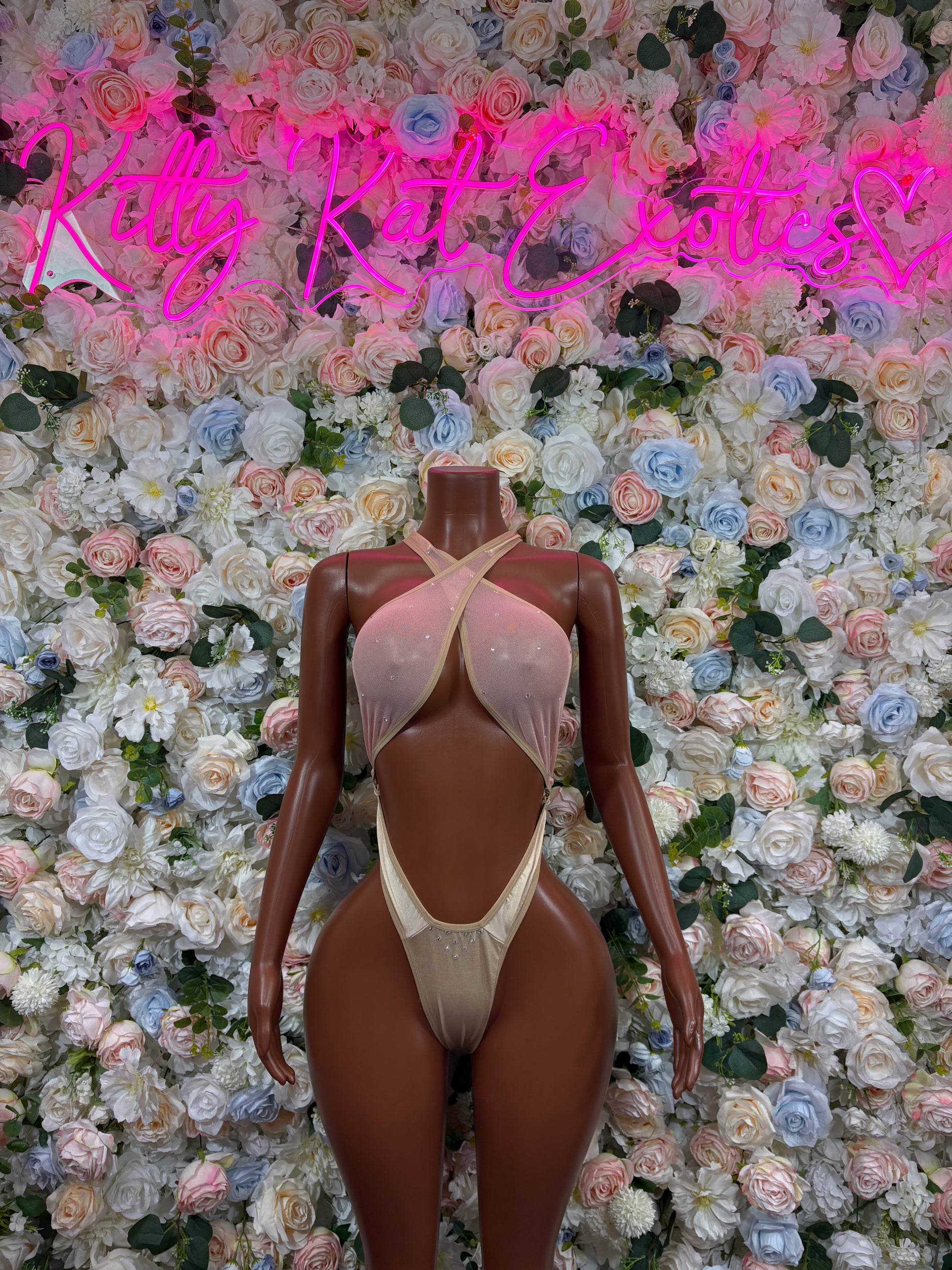 Light cream one-piece bodysuit with crisscross back straps and high-cut legs