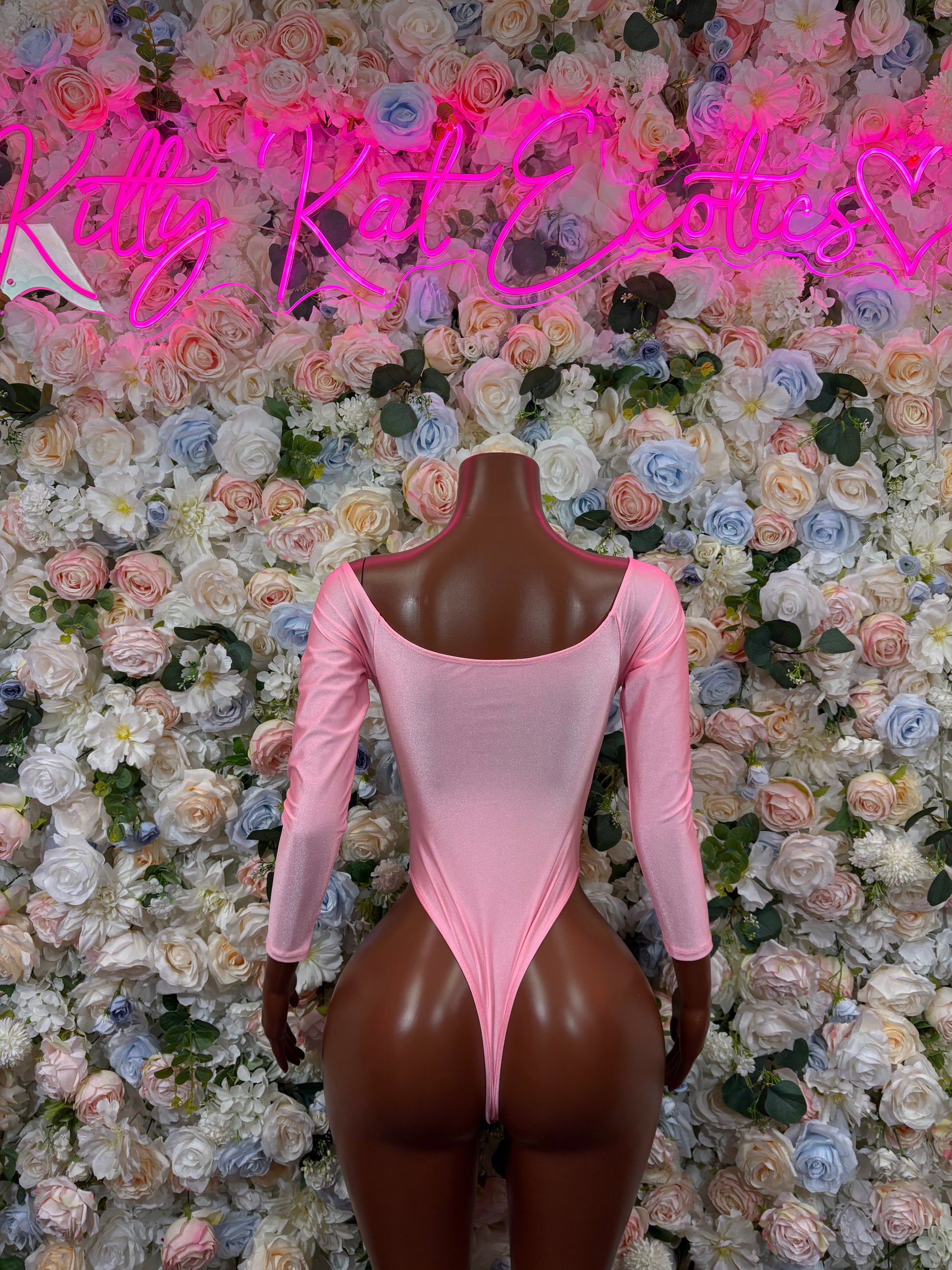 Pink long-sleeve bodysuit with scoop front and high-cut thong-style legs