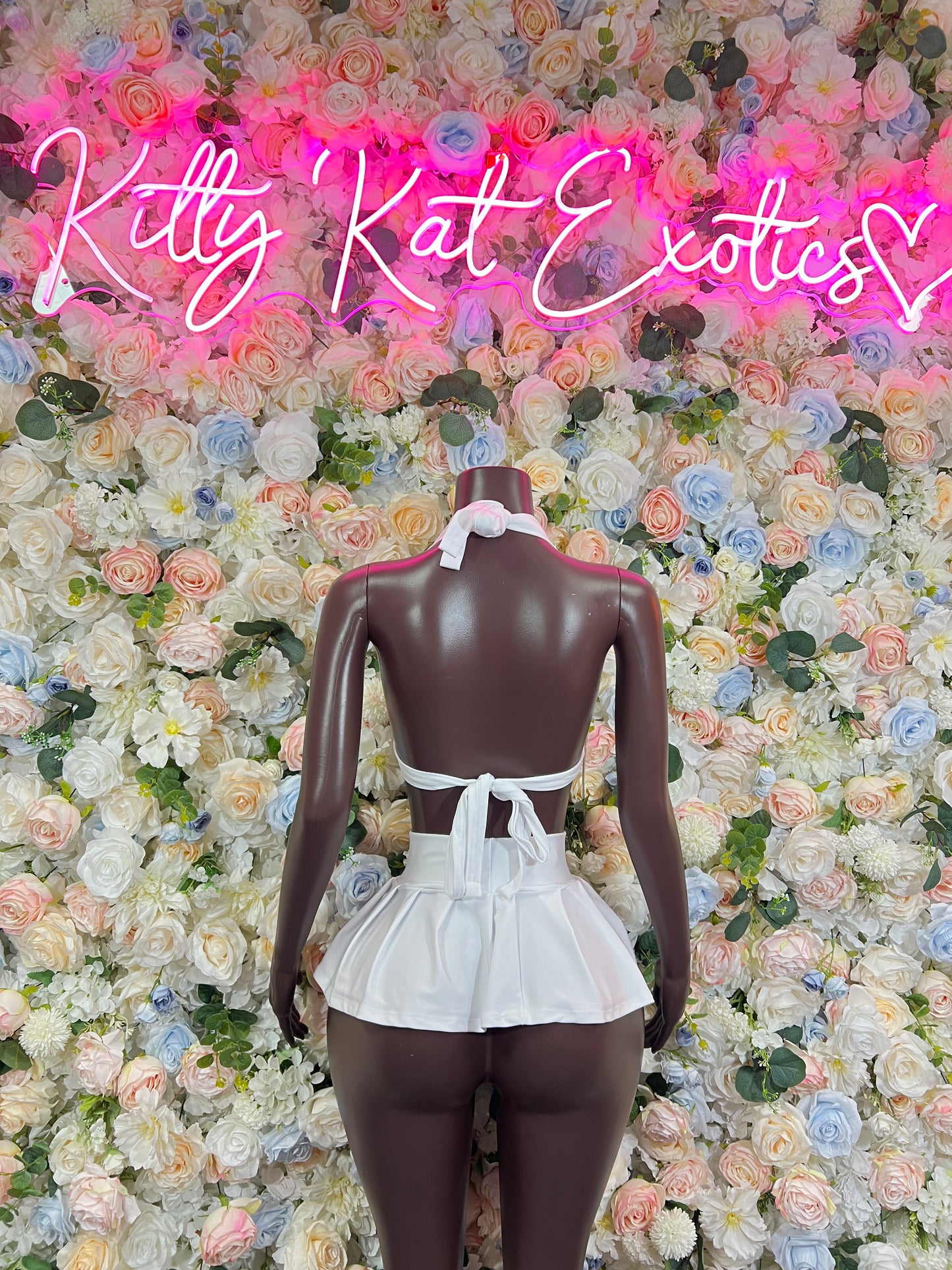 White two-piece rave set with halter crop top and ruffled mini skirt, back view