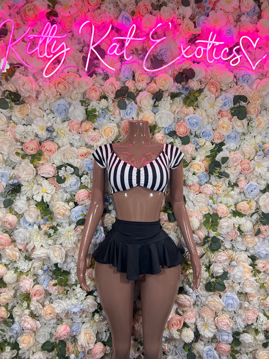 Black-and-white striped crop top and black pleated mini skirt on mannequin, front view