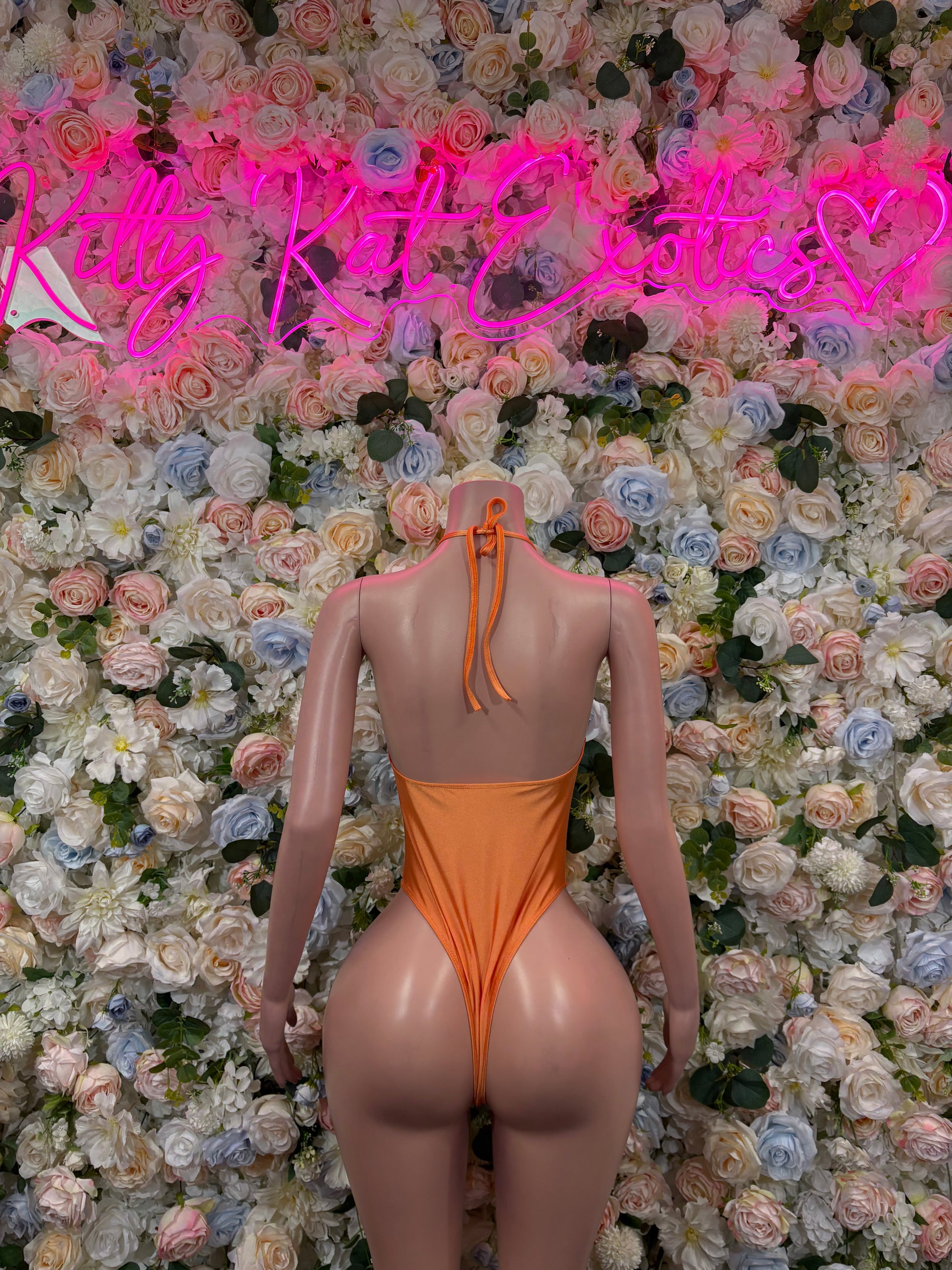Orange open-back one-piece bodysuit with tie halter straps