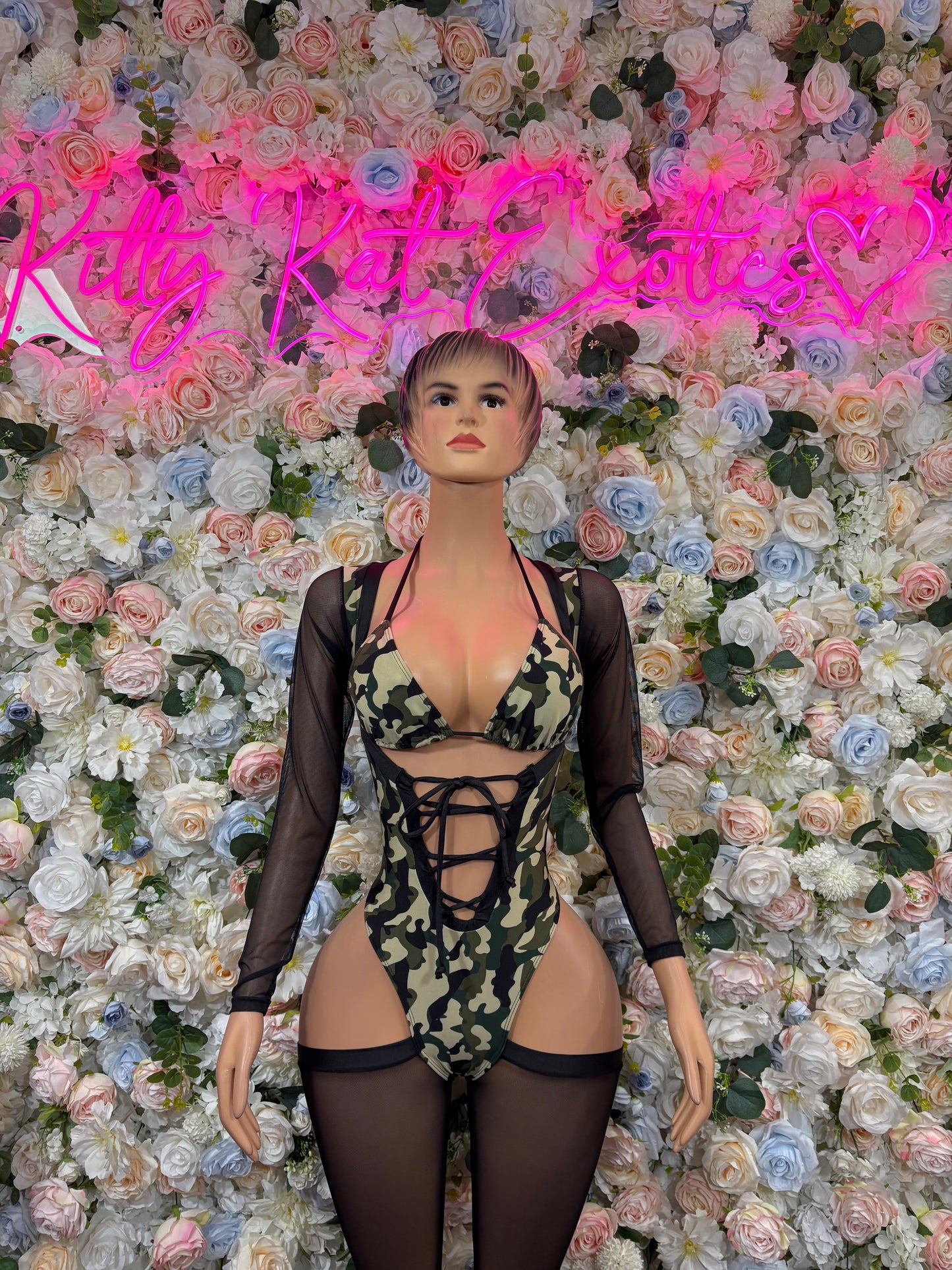 Camo print bodysuit with black mesh long sleeves, lace-up front and cutout sides