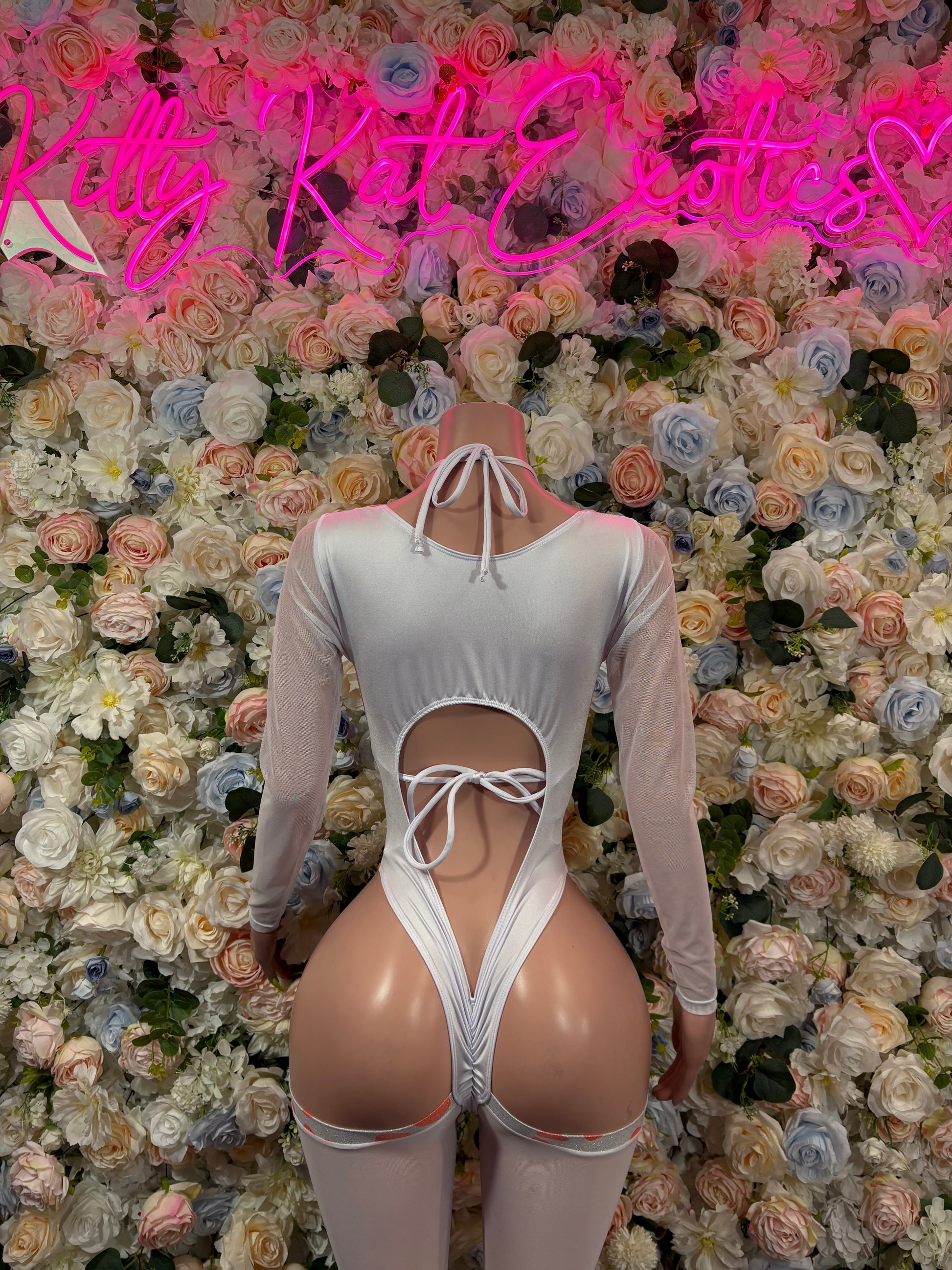 White long-sleeve bodysuit with orange cow print, open back and lace-up ties