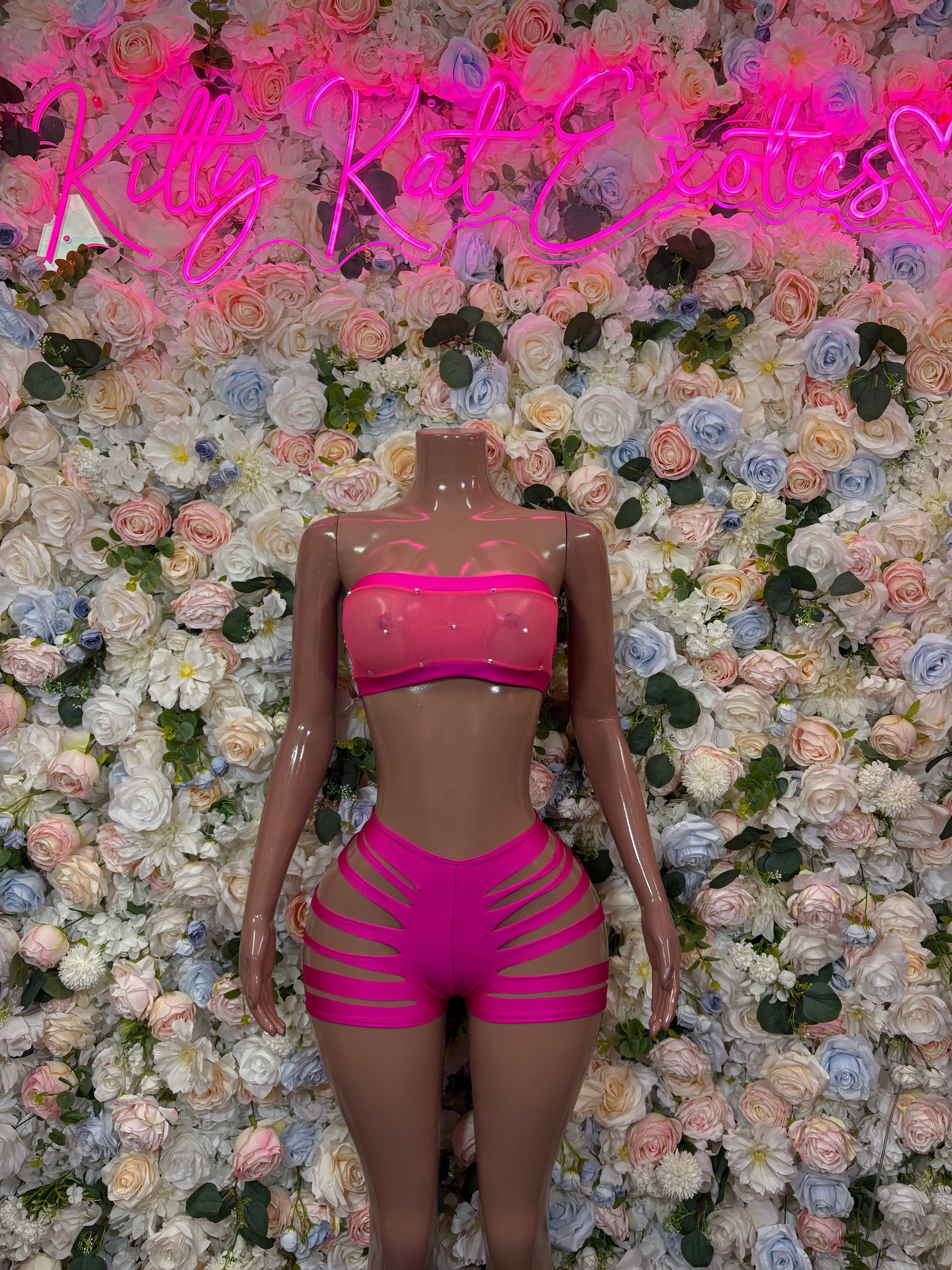 Pink two-piece rave set with bandeau top and high-waist cutout shorts, back view