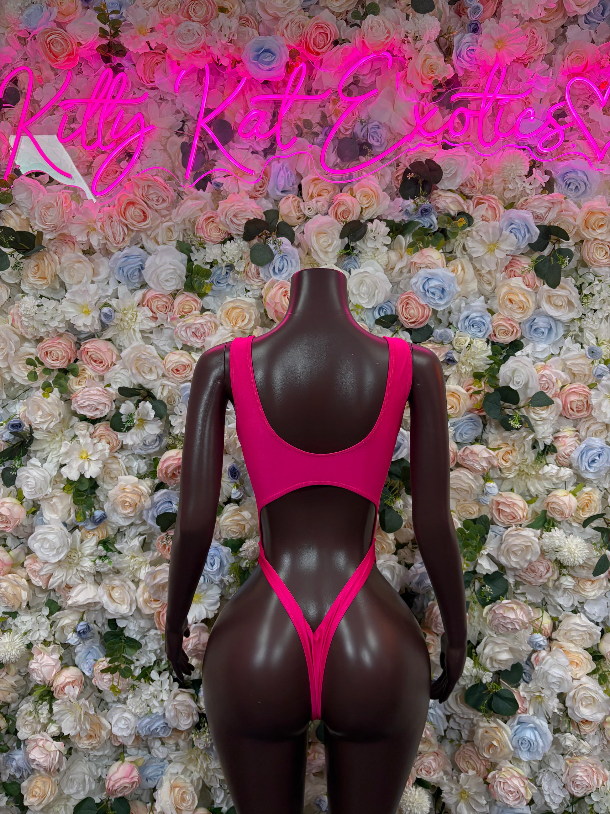 Pink sleeveless bodysuit on mannequin, high-cut with scoop neckline and narrow straps