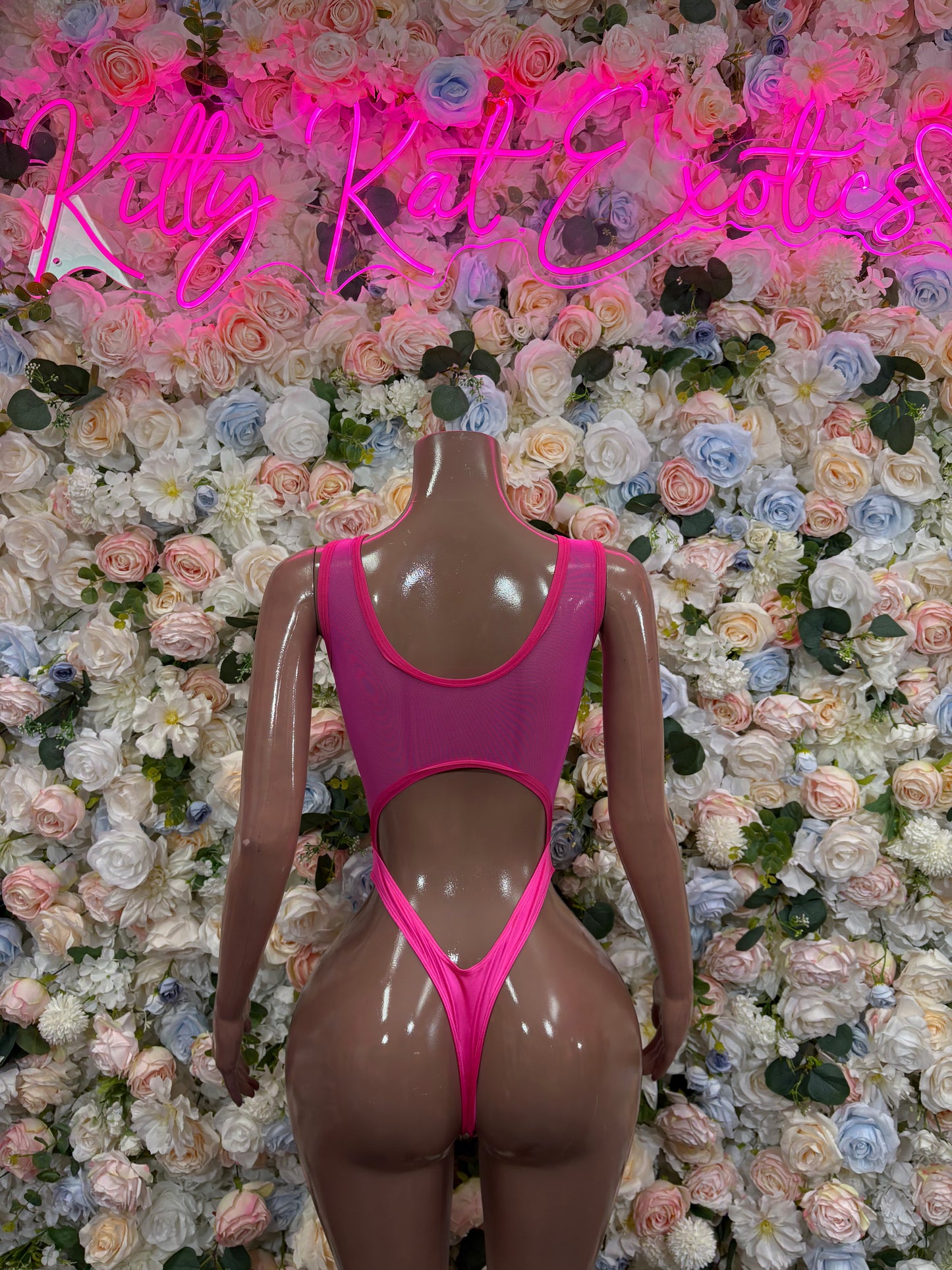Pink one-piece bodysuit front view, keyhole cutout at chest and high-cut leg openings