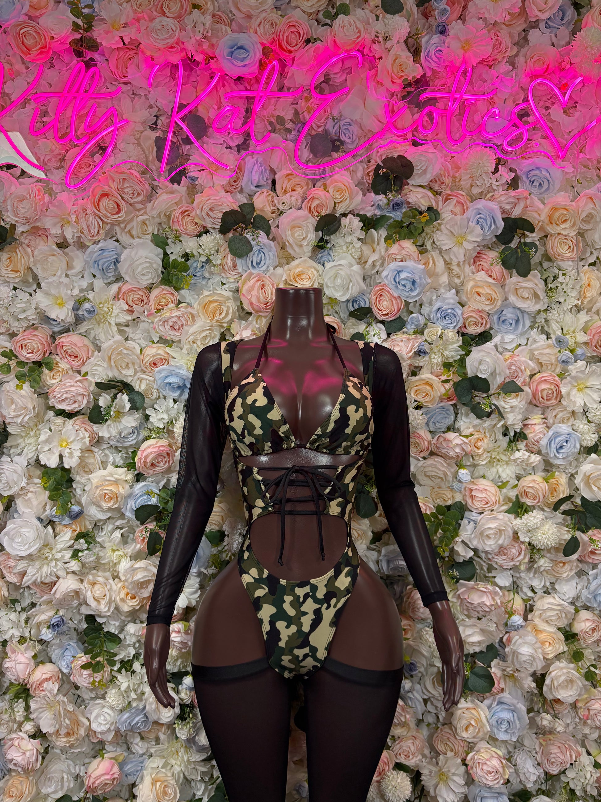 Camo print bodysuit with black mesh long sleeves, cutouts, and lace-up front