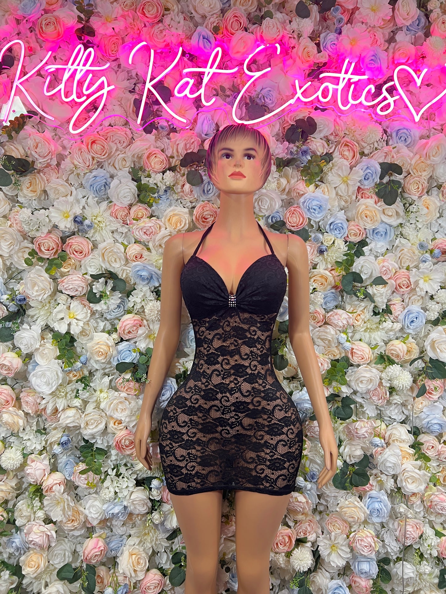 Black mini dress with sweetheart neckline, sheer lace panel and bow-tied front
