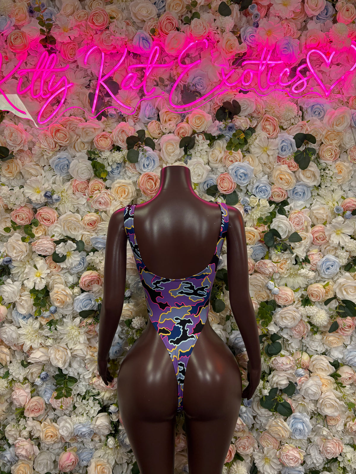 Purple camo print bodysuit with scoop neckline and thin straps on mannequin