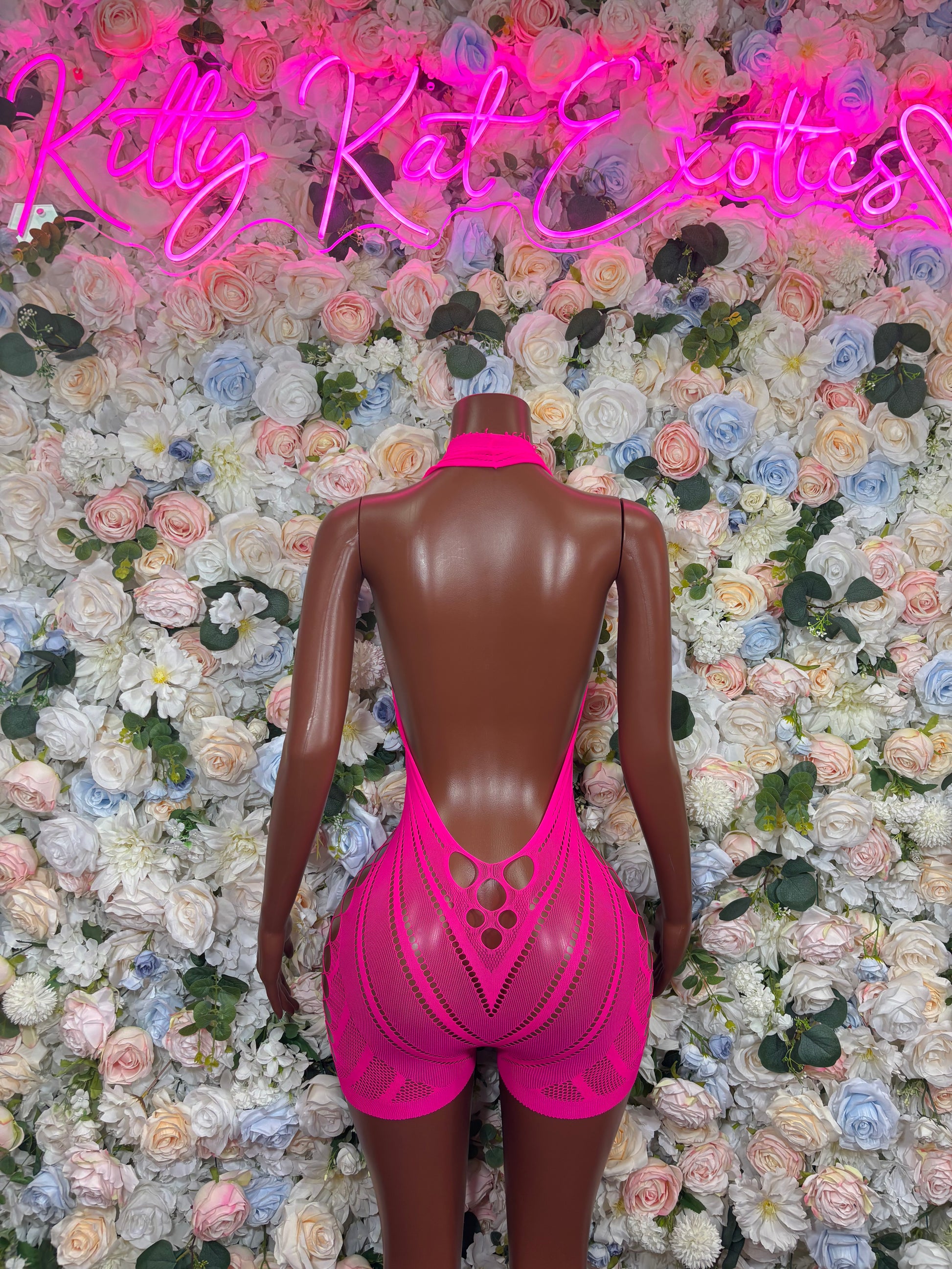 Hot pink fishnet halter romper with open-back geometric cutouts and lattice