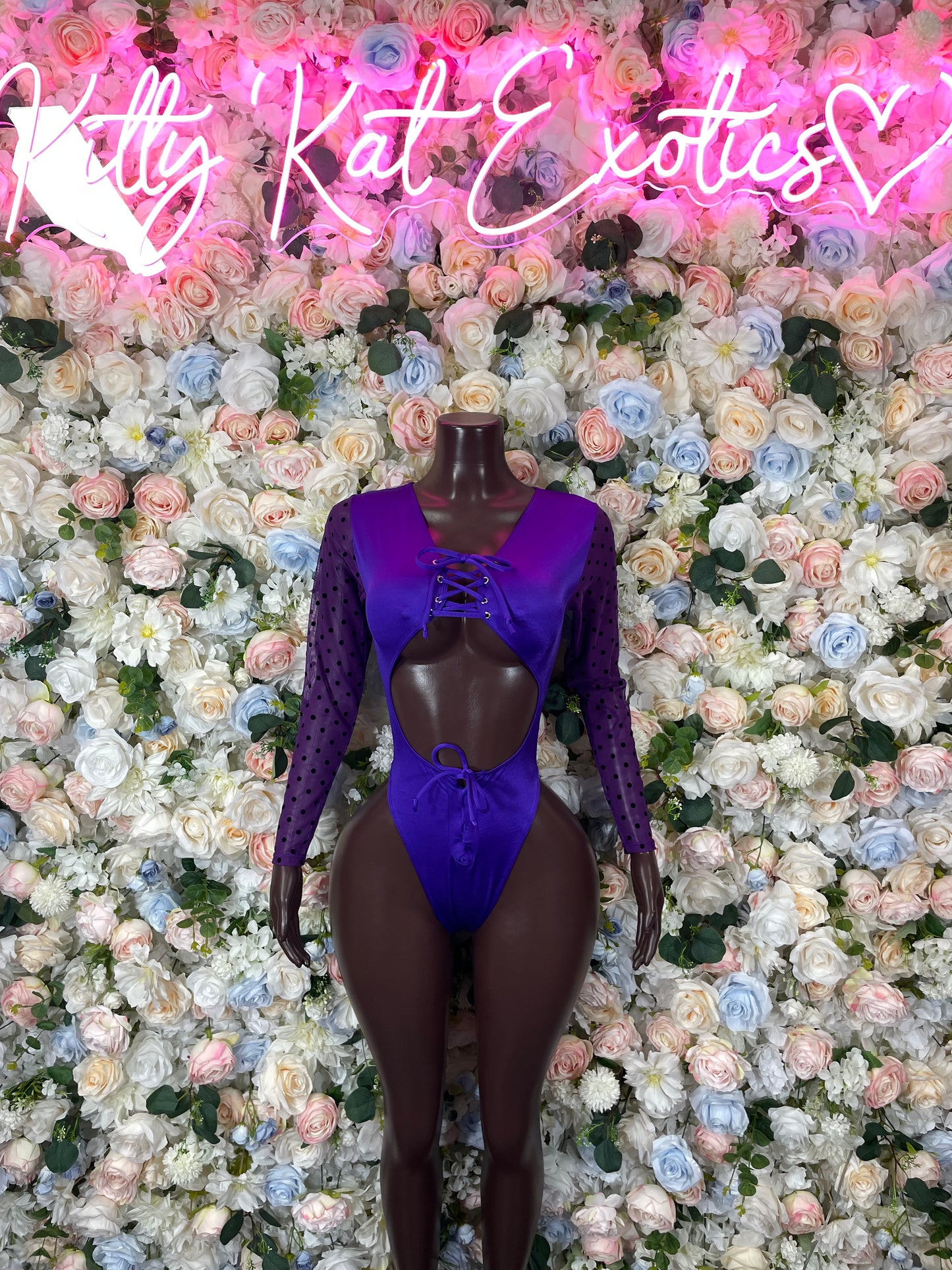 Purple long-sleeve bodysuit with deep V front and tie detail on mannequin