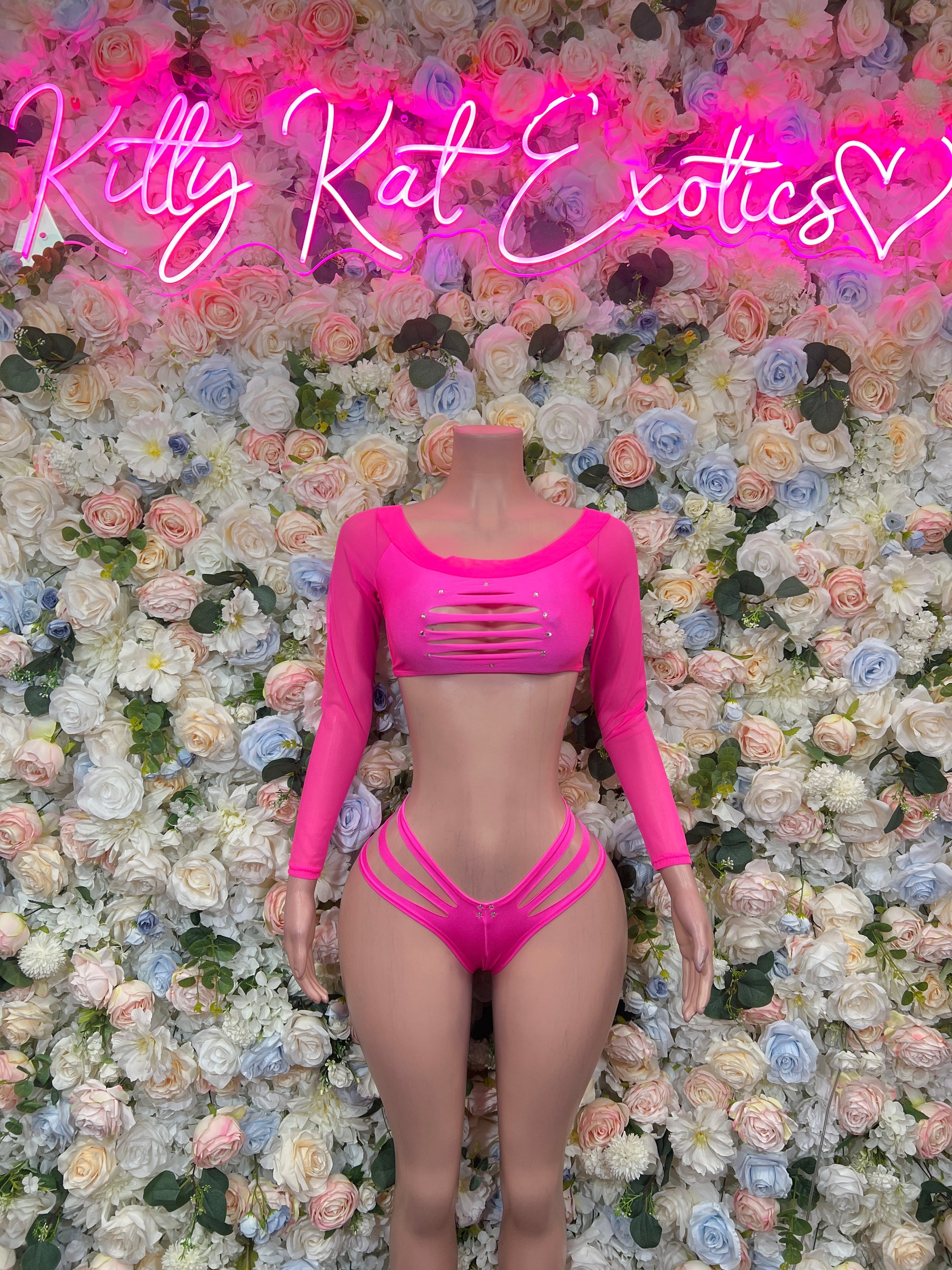 Hot pink two-piece rave swimsuit with crisscross long-sleeve crop top and strappy bottoms