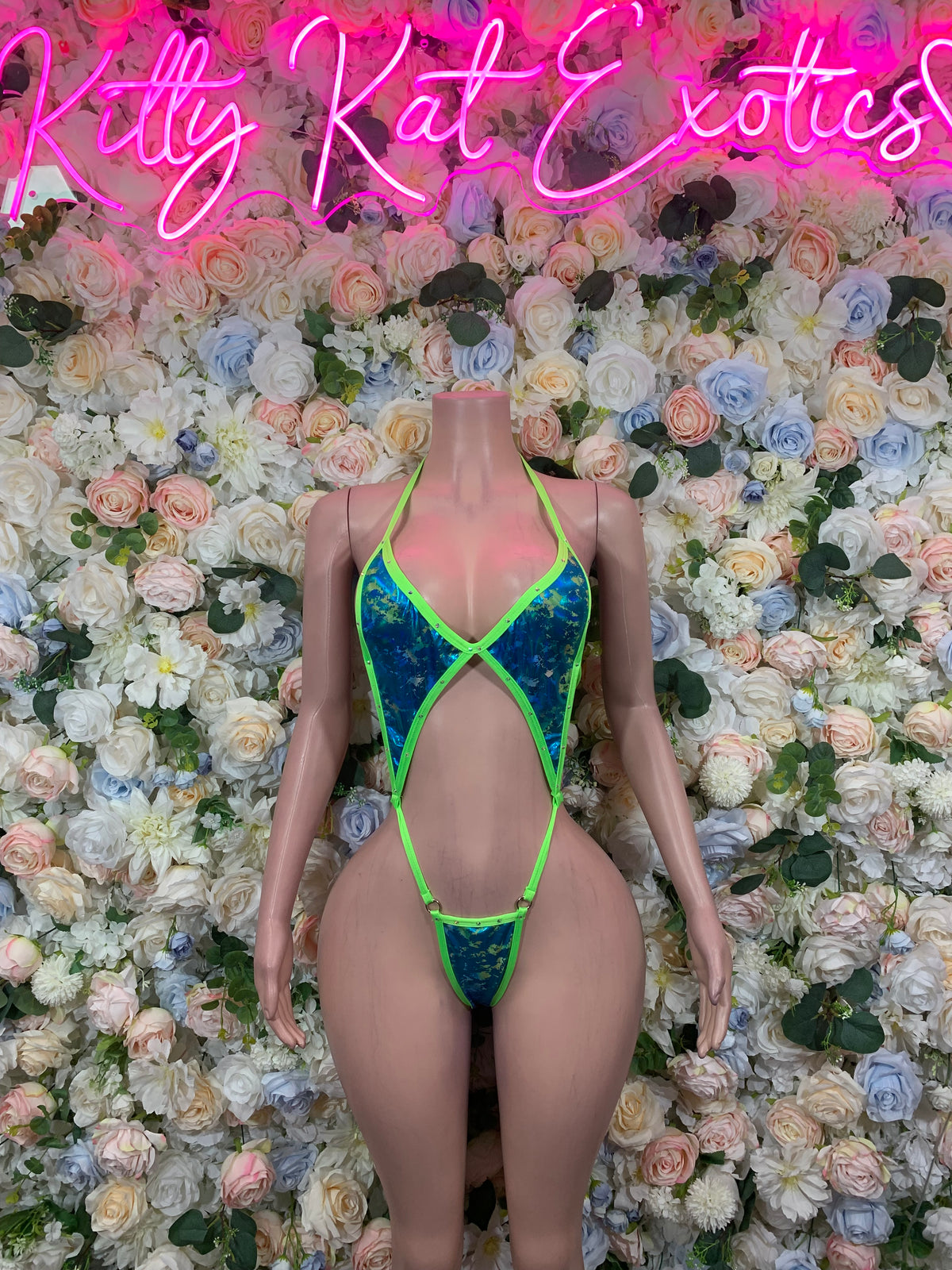 Neon green and blue patterned bodysuit with crisscross straps and high-cut legs