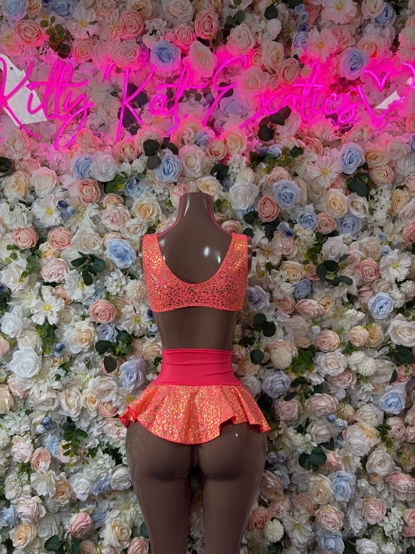 Coral glitter two-piece dance skirt set with scoop neckline and ruffled peplum skirt