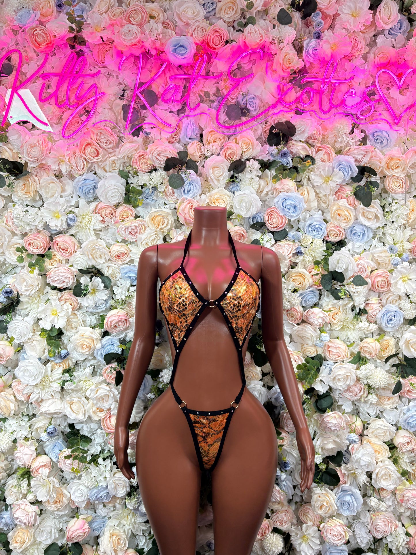 Orange snake-print one-piece bodysuit with thin black straps and V-neck